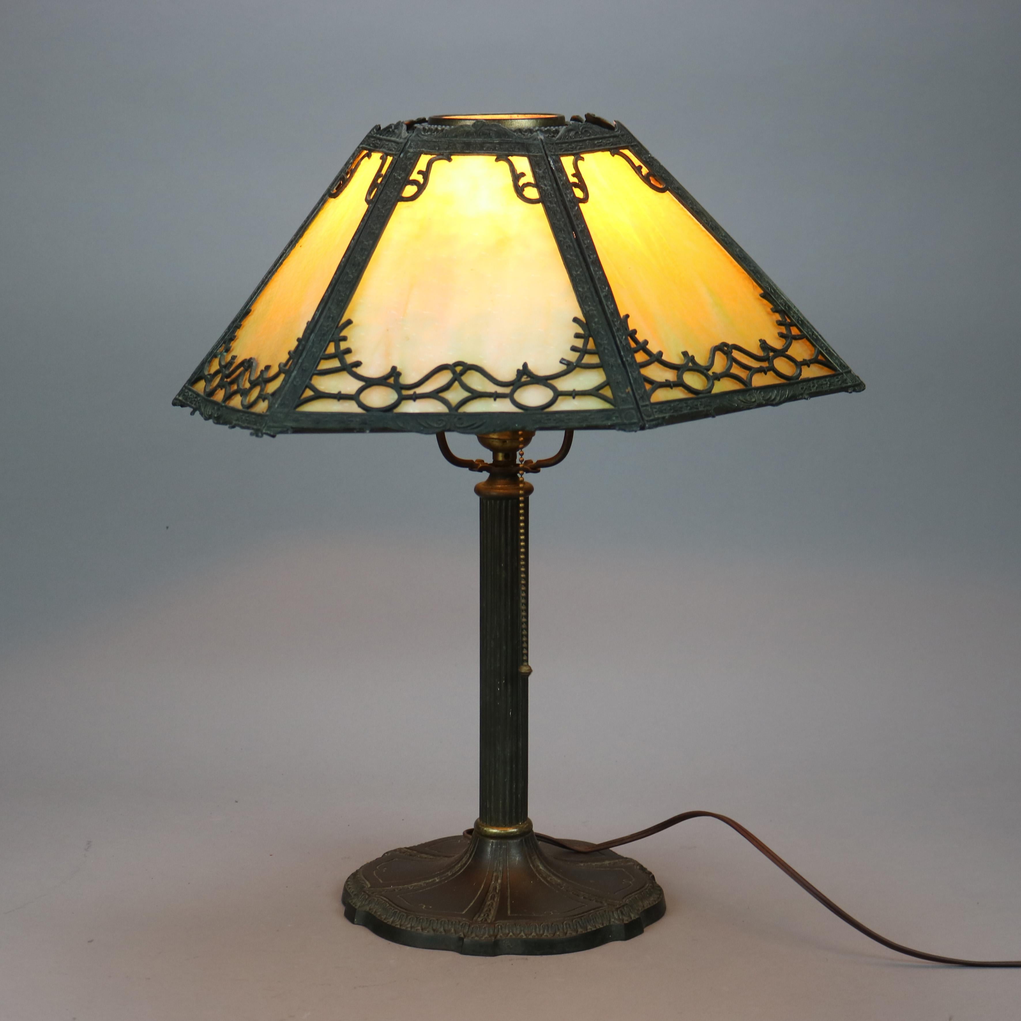 An antique Arts and Crafts table lamp by Miller offers flared cast filigree shade housing slag glass panels over single socket base, maker mark on base as photographed, c1920

Measures - 20.25''H x 16''W x 16''D.