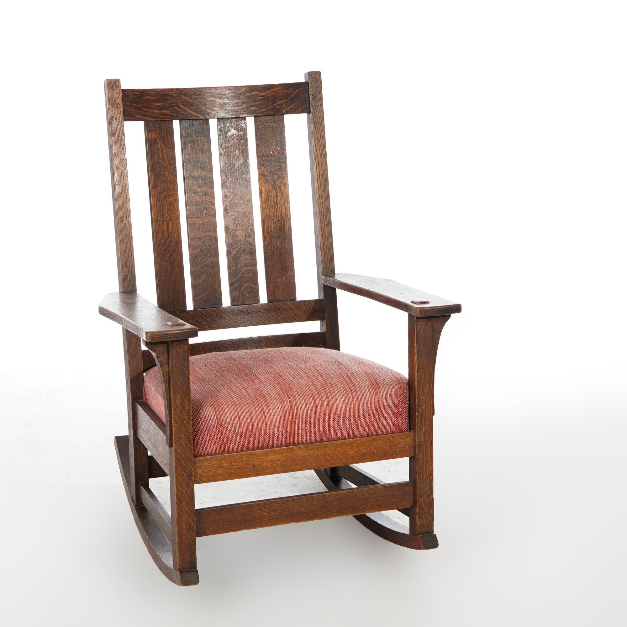 An antique Arts & Crafts Mission L & JG Stickley rocker offers quarter sawn oak construction with curved slat back, arms with concave corbels, and original label as photographed, c1910

Measures- 40.25'' H x 27.75'' W x 29'' D.