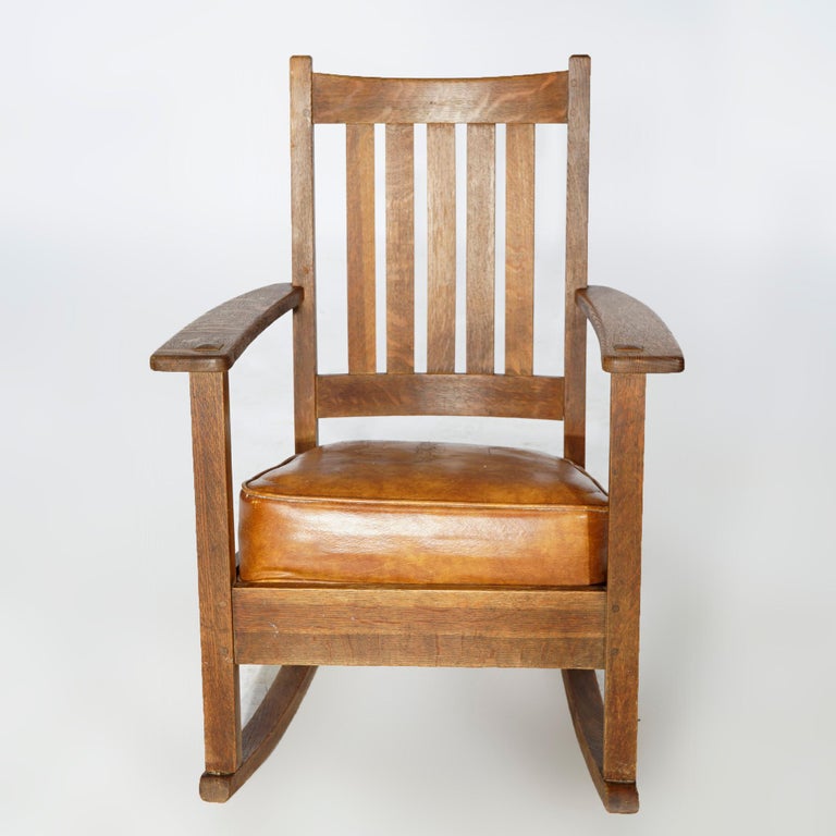 Antique Arts and Crafts Mission rocking chair by Limbert offers quarter sawn oak construction with slat back and upholstered seat, signed as photographed, c1910

Measures- 34''H x 24.75''W x 29.5''D.