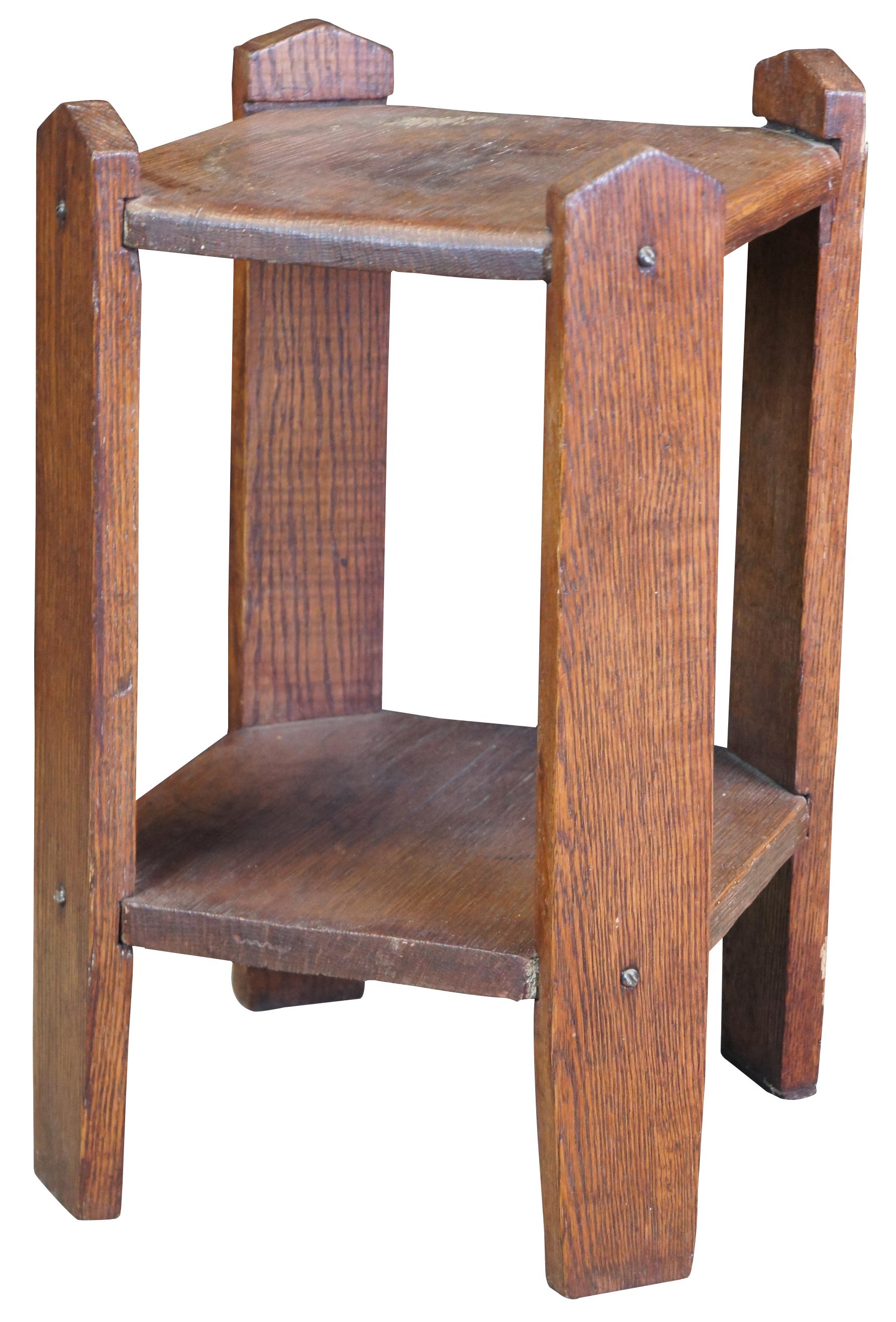 Early 20th century mission plant stand. Made from oak with an open two tier design. Supported by spear or fence shaped supports.  Measure: 19