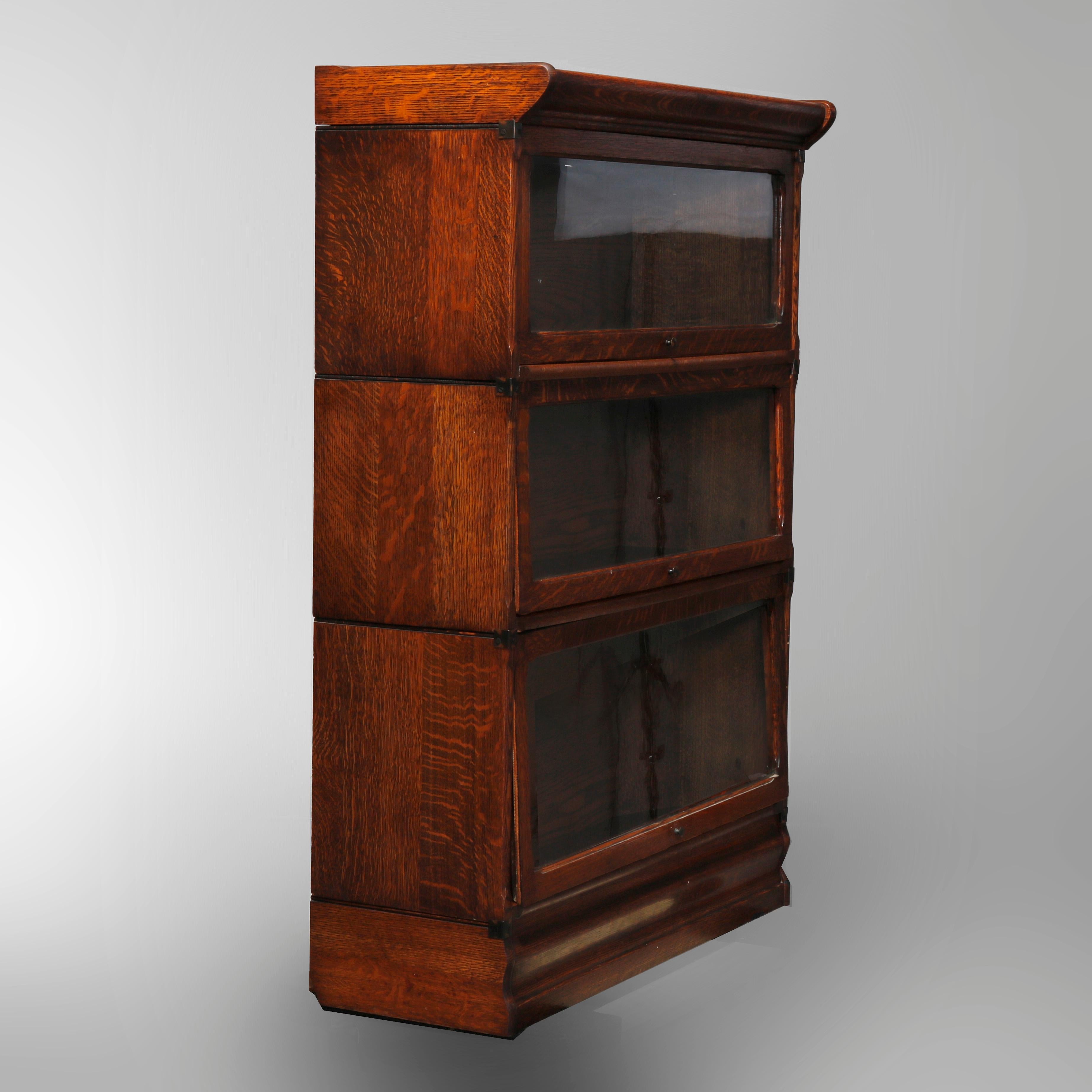 An antique Arts & Crafts Mission Barrister stacking bookcase in the manner of Globe Wernicke offers quarter sawn oak construction with three sections having pull-out glass doors, circa 1910

Measures: 47.25