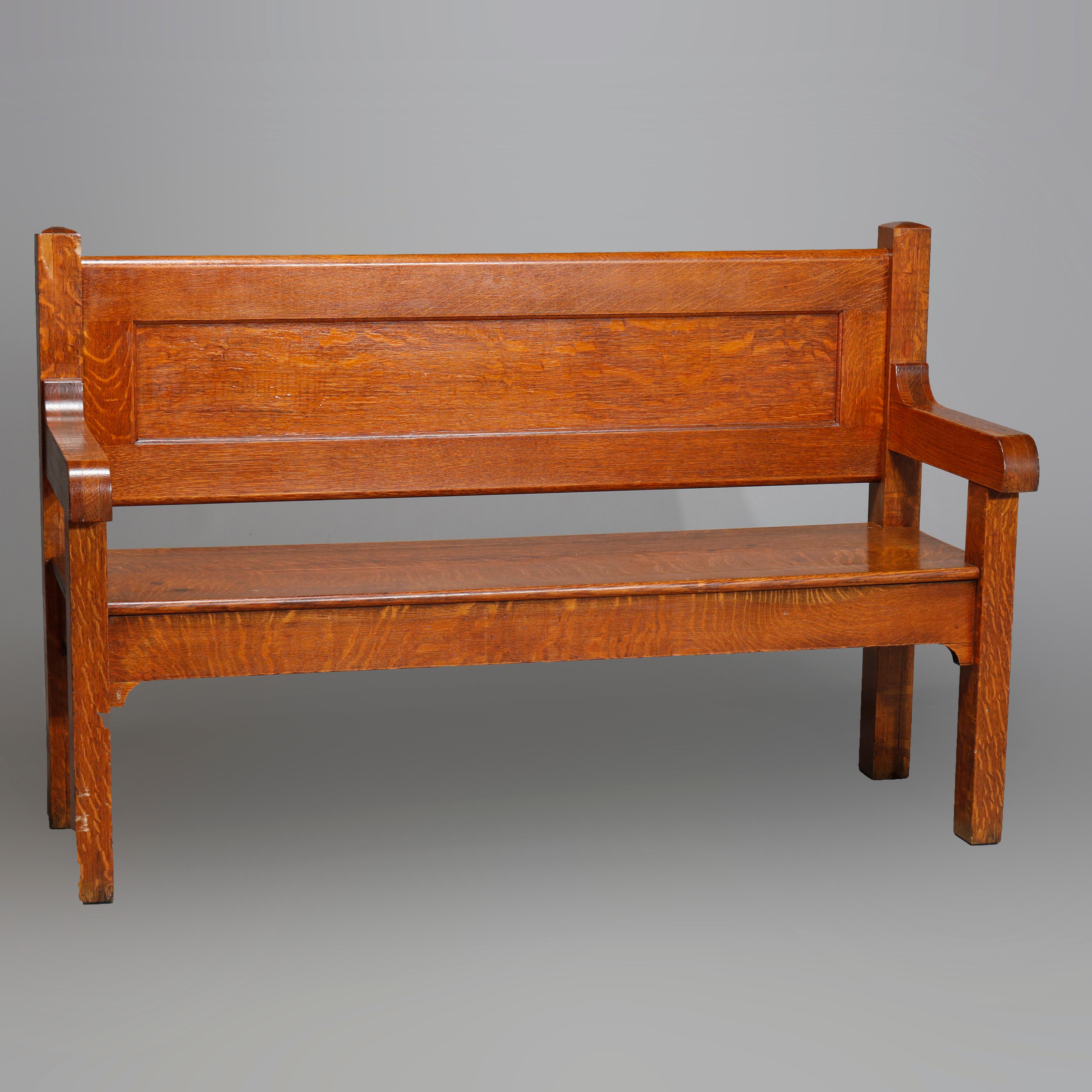 An antique Arts & Crafts Mission bench settle offers quarter sawn oak construction with paneled back and raised on square and straight legs having rounded corbels, circa 1910

Measures: 39.25