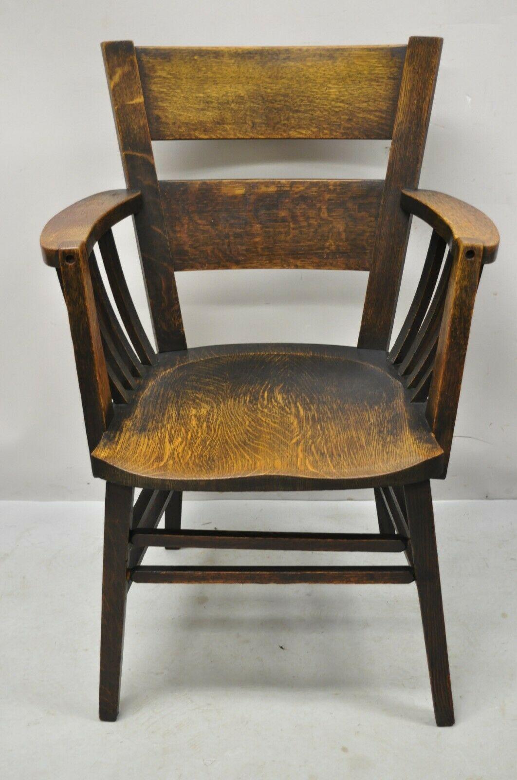 Antique Arts & Crafts mission oak bowed spindle plank seat arm chair. Item features bowed spindle slat sides, plank seat, solid wood construction, beautiful wood grain, very nice antique item. Circa early to mid 1900s. Measurements: 37