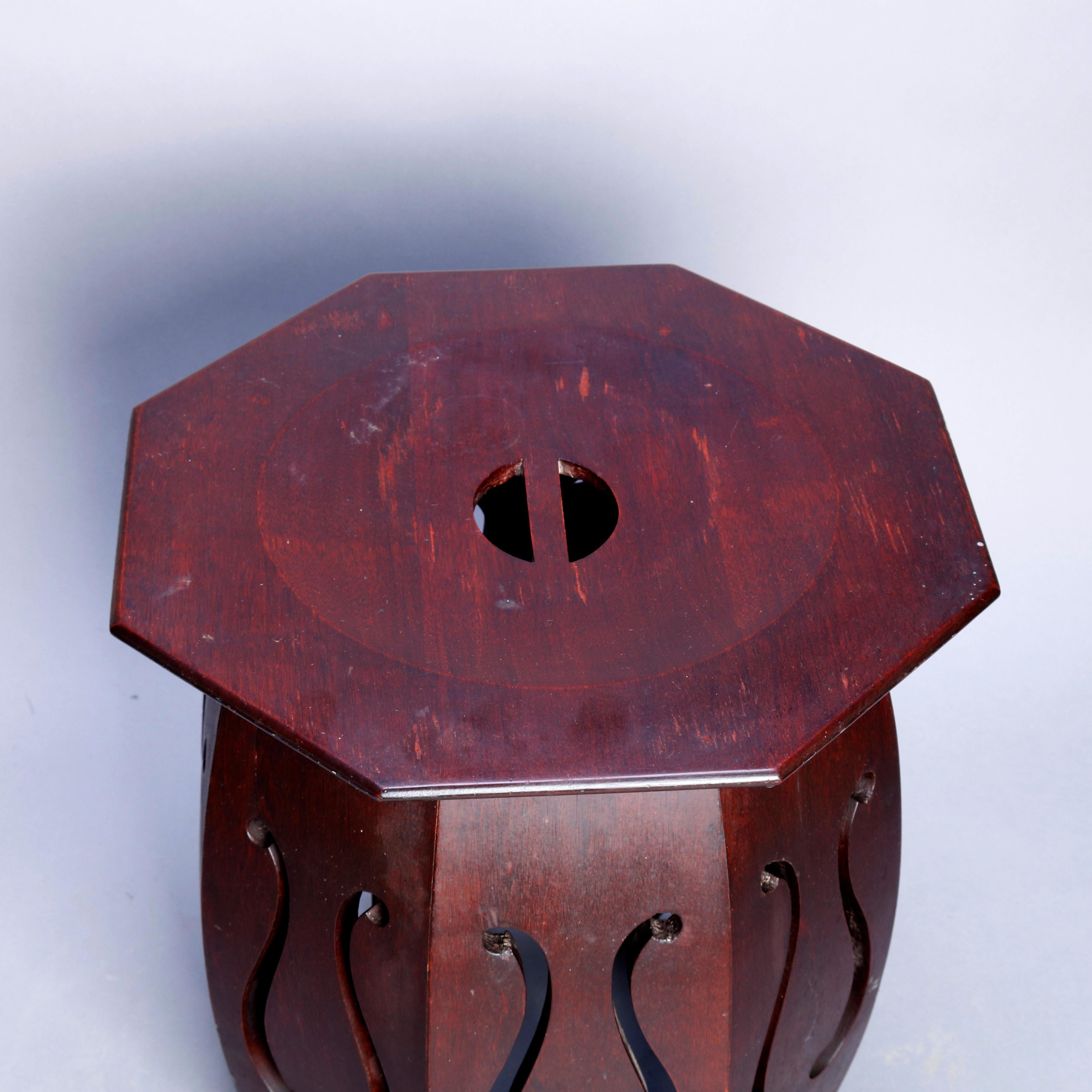 An Arts & Crafts taboret stand offers bent oak sides with stylized lyre and clover form cutout designs, circa 1910.

Measures: 17.75