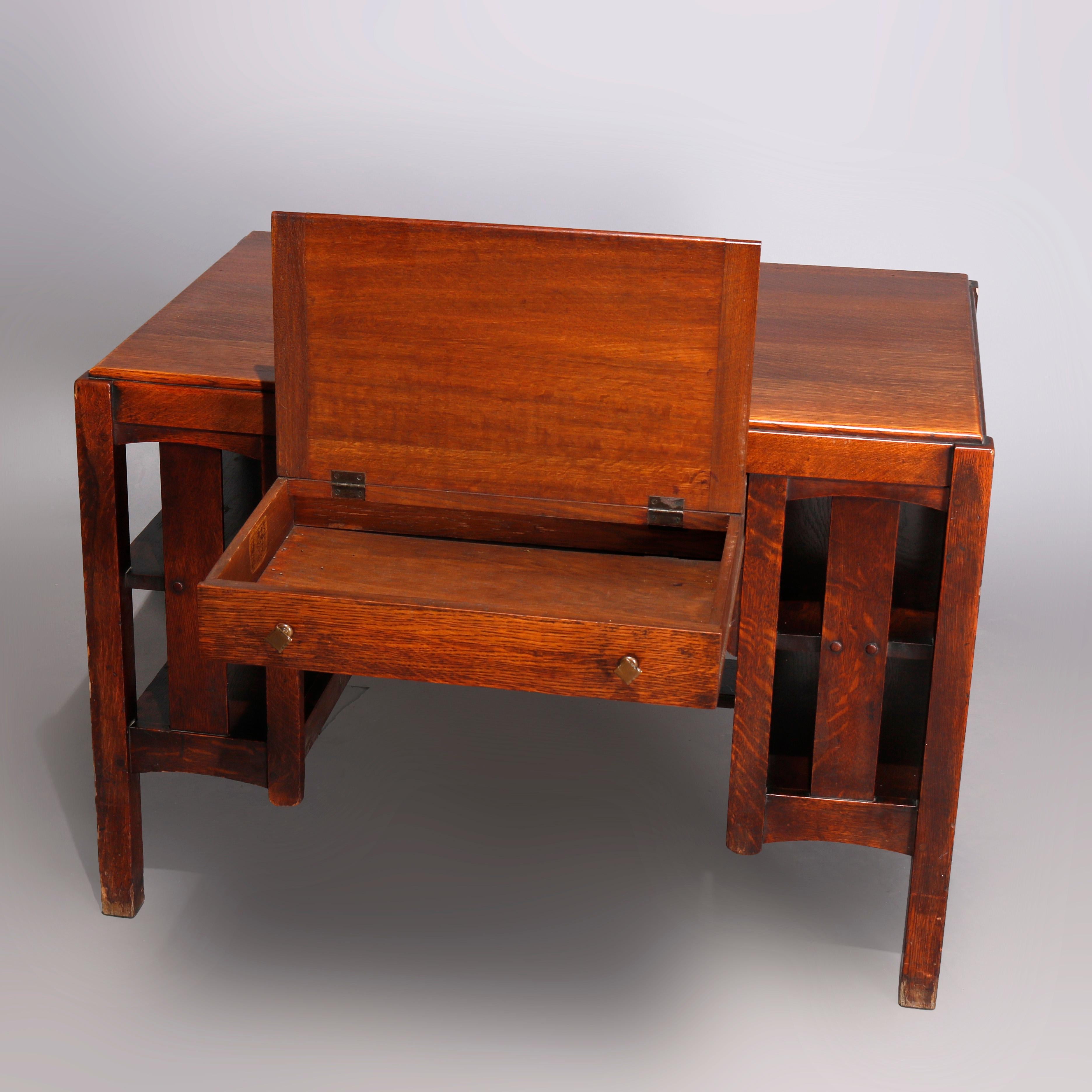 An antique Arts & Crafts mission oak desk or library table by Limbert offers central single flip-top drawer flanked by book shelves with slat sides, drawer reminiscent of artist work station, maker stamped as photographed, circa 1910

Measures: