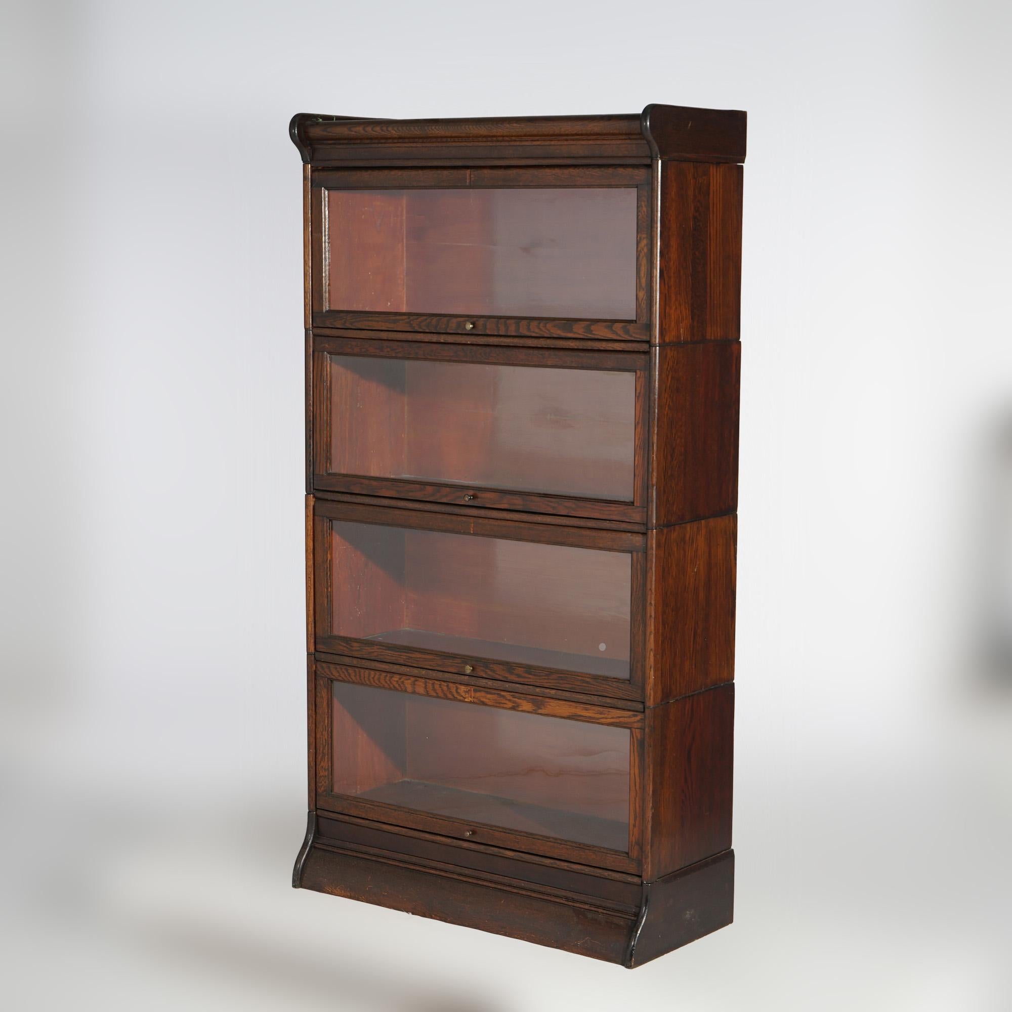 An antique Arts and Crafts Mission barrister bookcase offers oak construction with four stacks each having pull out glass doors and raised on ogee base, c1910

Measures - 63