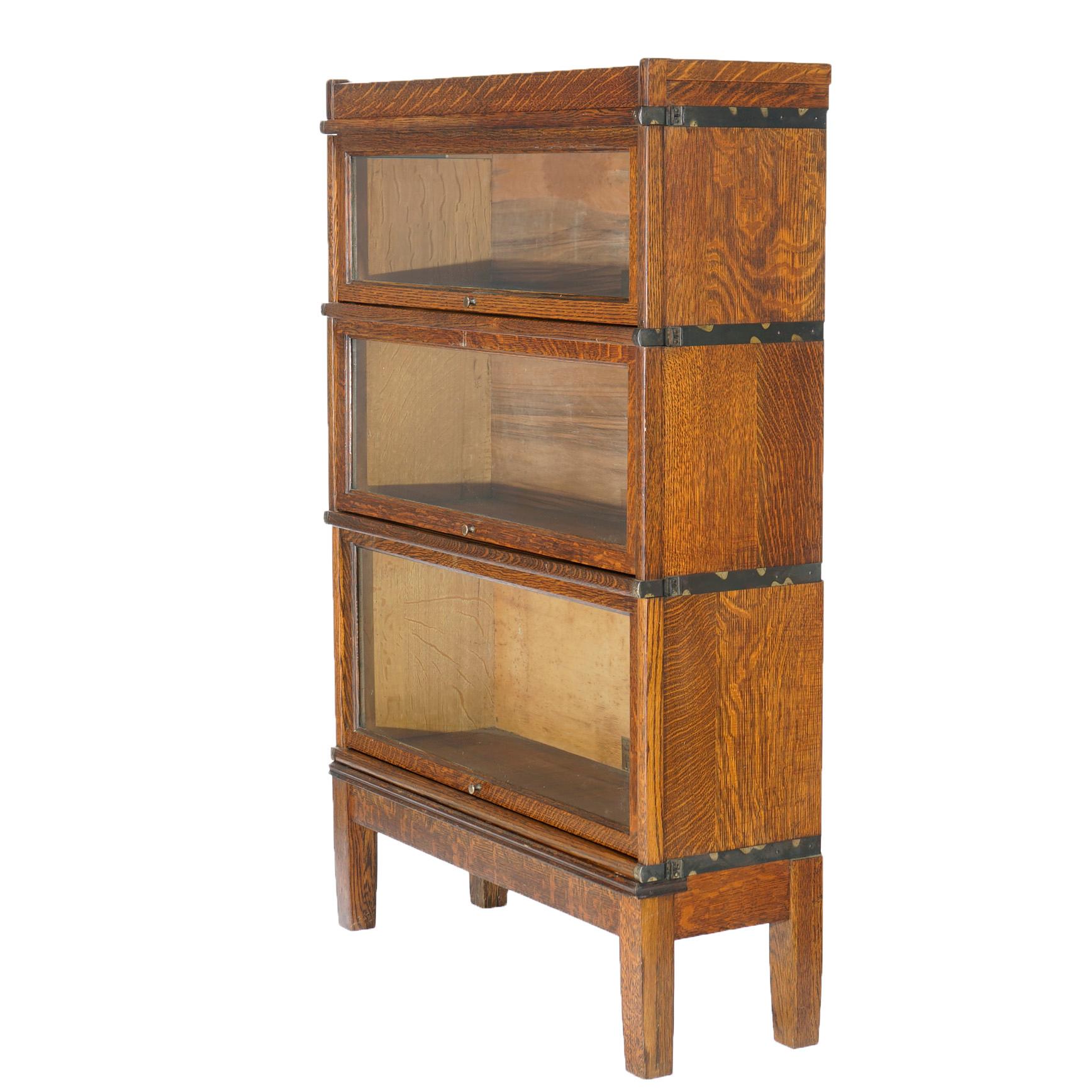 An antique Arts & Crafts Mission barrister bookcase by Globe Wernicke offers quarter sawn oak construction with three stacks each having pull-out glass doors over base with square and straight legs, maker label as photographed, c1910

Measures-