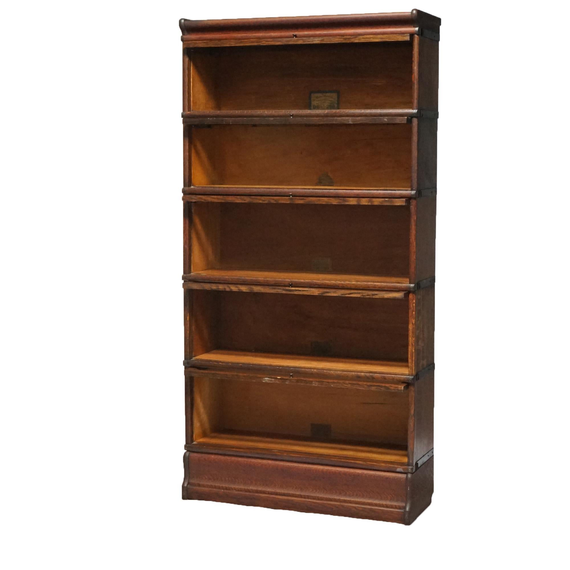 An antique Arts and Crafts Mission barrister bookcase by Globe Wernicke offers quarter sawn oak construction with five stacks each having slide out doors and seated on ogee base, maker label as photographed, c1910

Measures - 68.25'' H x 34'' W x