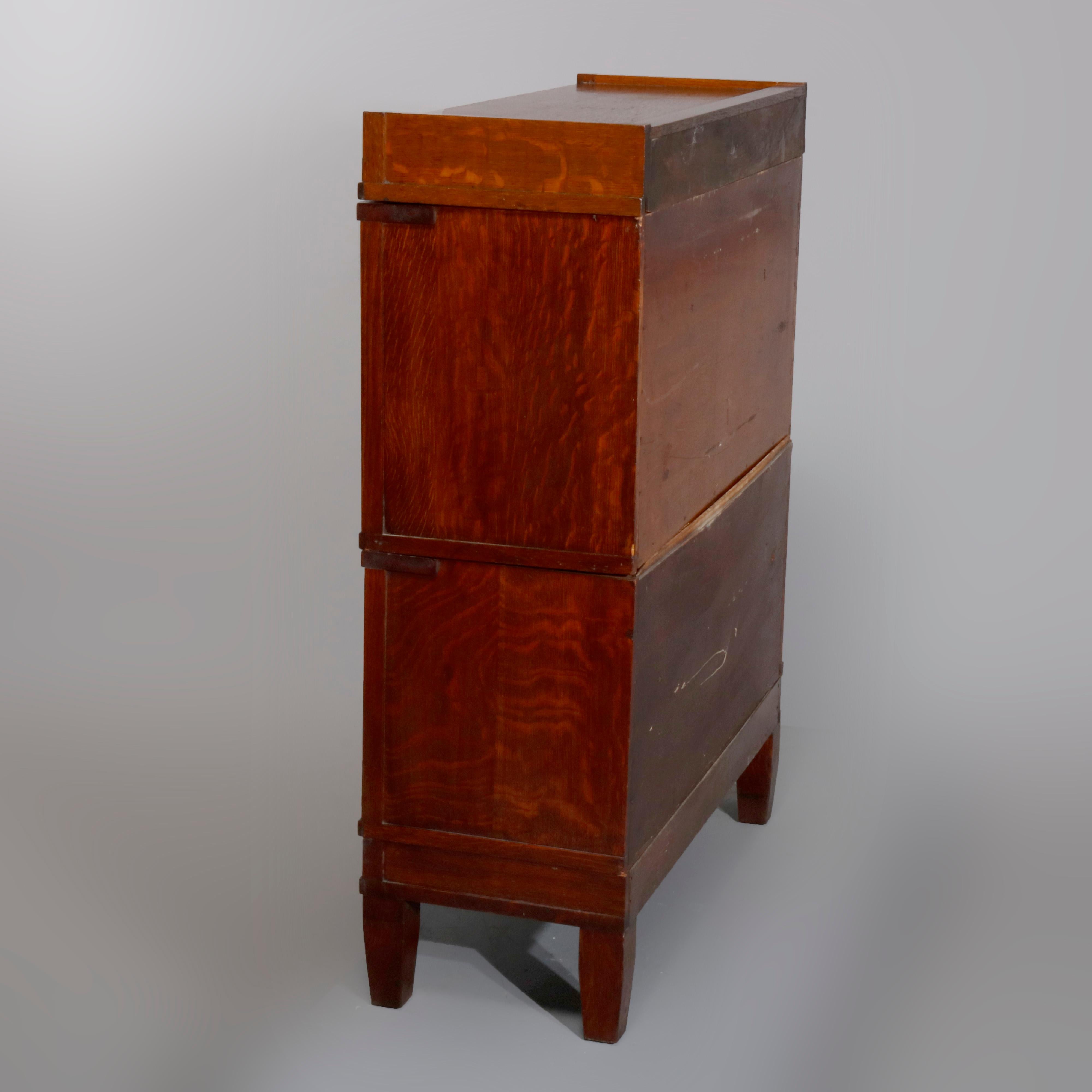 An antique Arts & Crafts mission oak barrister bookcase in the manner of Globe Wernicke offers quarter sawn oak construction with two stacks, each having pull-out glass doors and raised on tapered square legs, circa 1910.

Measures: 44.75
