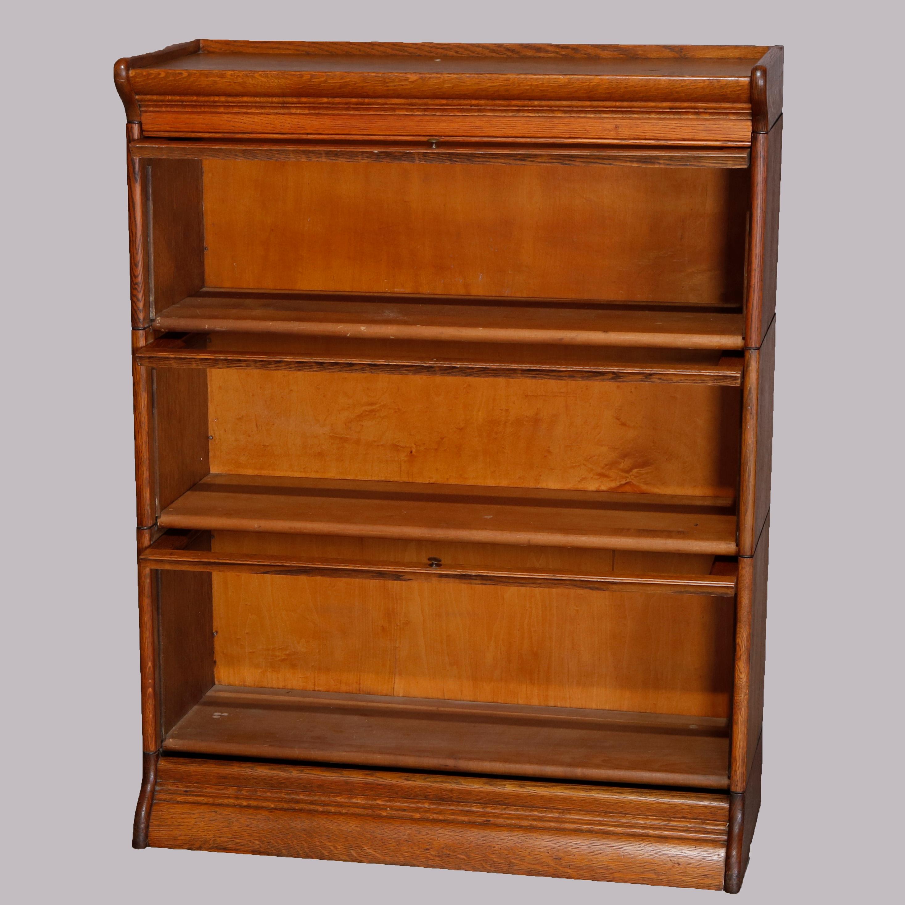 An antique Arts & Crafts mission oak barrister bookcase offers quarter sawn oak construction with three stacks, each having a pull-out glass door, en verso original GRM label as photographed, circa 1910

Measures: 44.5