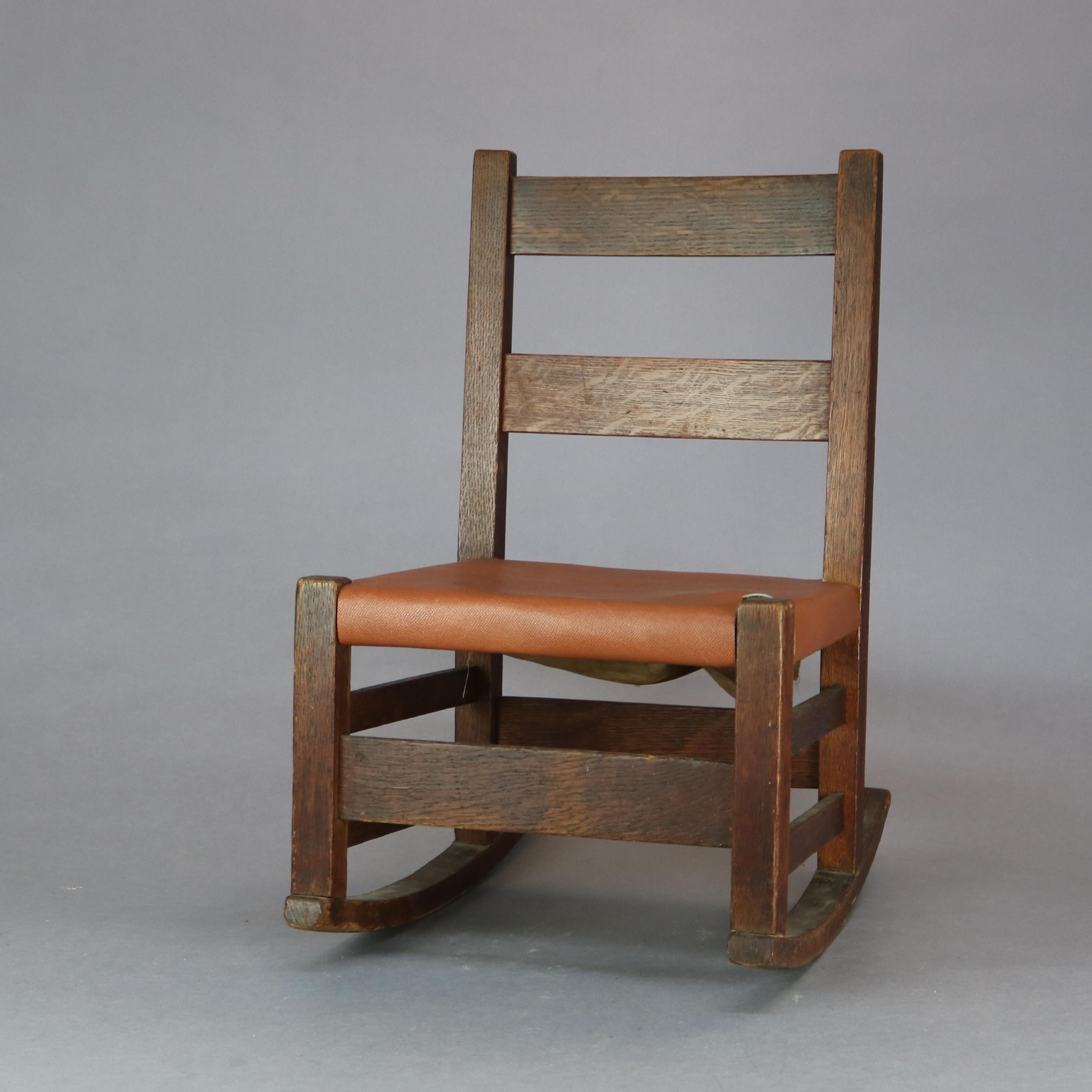 An antique Arts & Crafts Mission child's rocker by Gustav Stickley offers oak construction with ladder back, unsigned, c1910

Measures: 23
