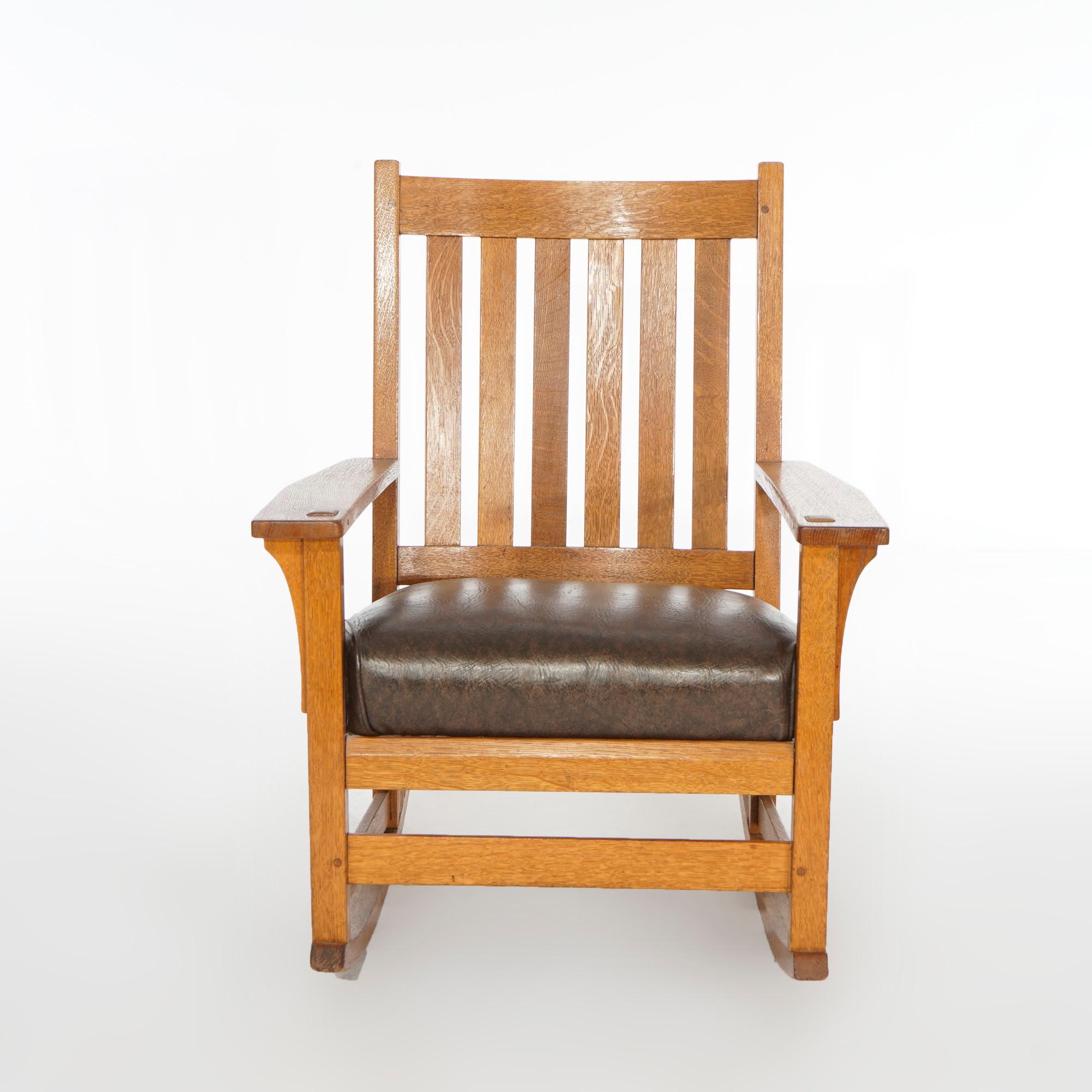 An antique Arts and Crafts L & JG Stickley rocker offers quarter sawn oak construction with slat back over upholstered seat, c1910

Measures- 35.25'' H x 27.25'' W x 30'' D.
