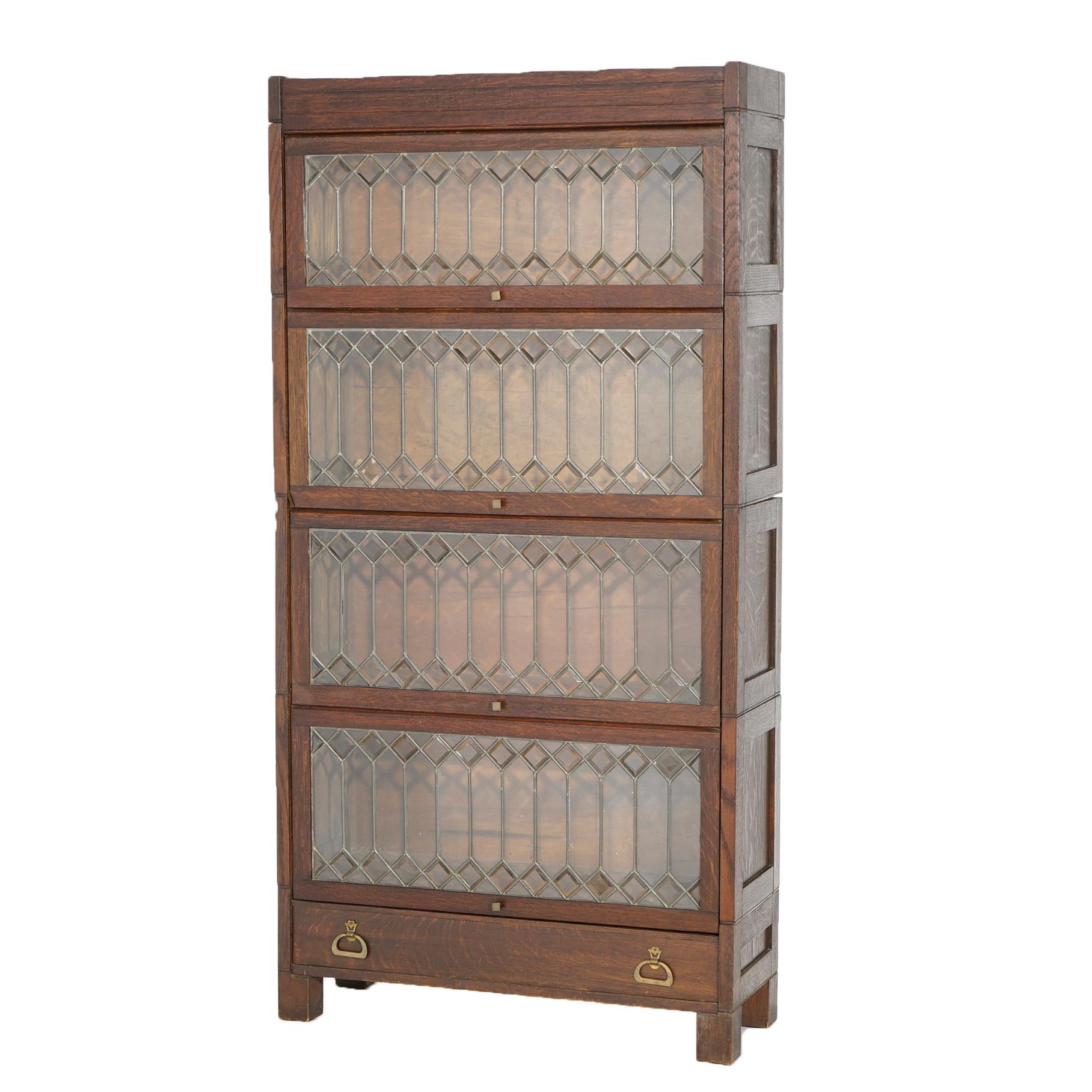 An antique Arts and Crafts Mission barrister bookcase offers oak construction with four stacks, each having pull out leaded glass doors, over base with drawer and raised on straight and square legs, circa 1910.

Measures- 66.75