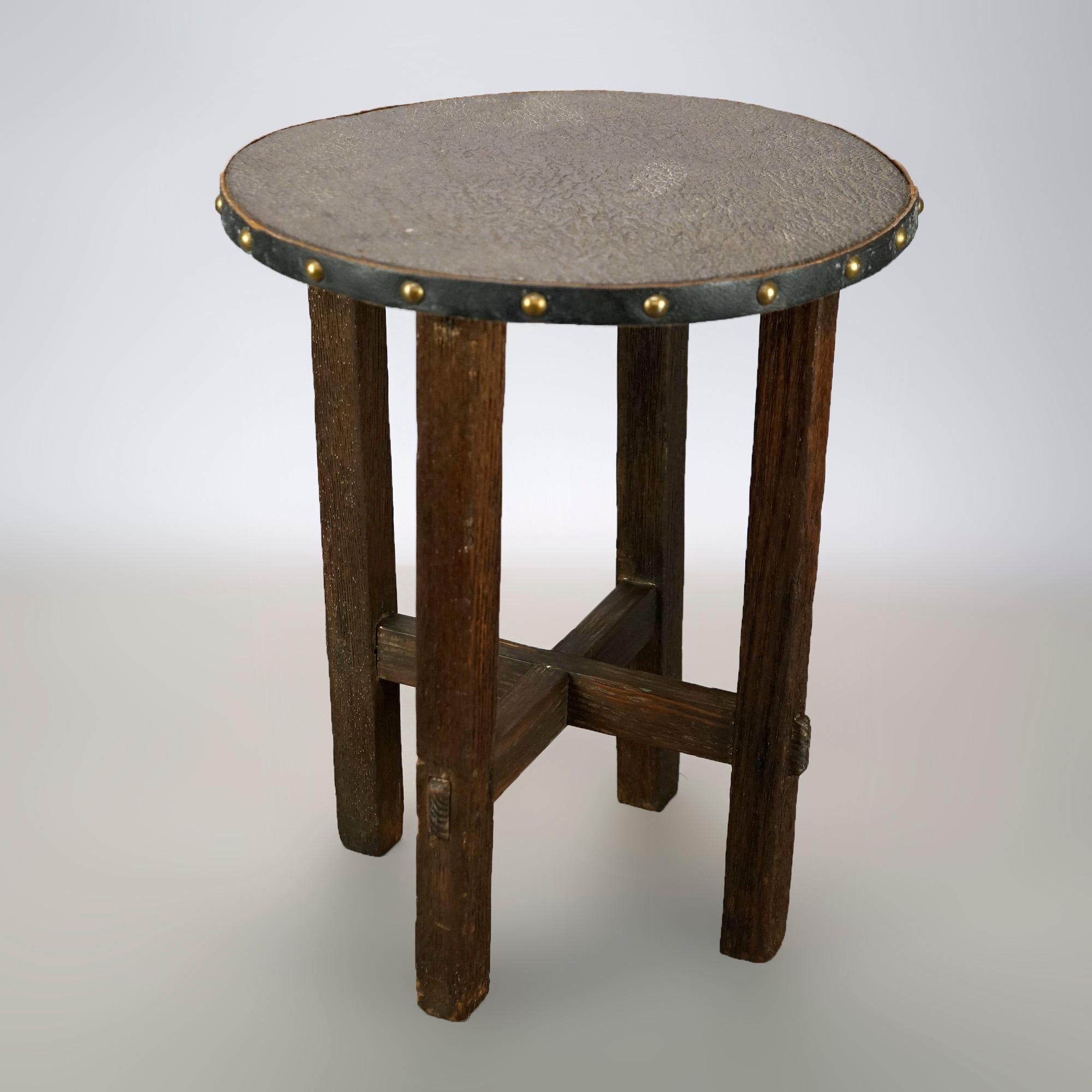 An antique Arts and Crafts Mission taboret stand offers oak construction with leather covered top raised on straight and square legs having x-form stretcher, c1910

Measures- 17.5''H x 14.25''W x 14.25''D.