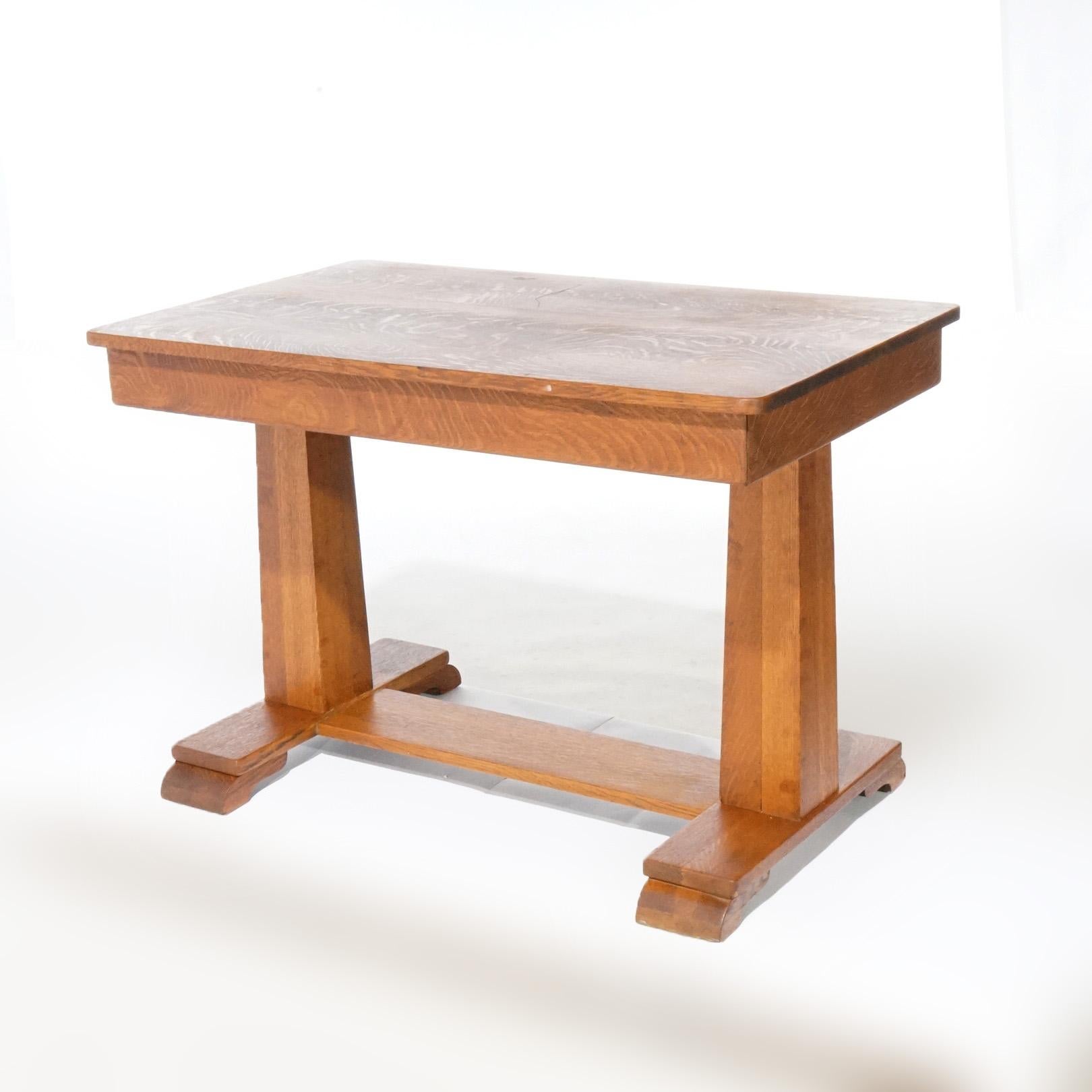 An antique Arts and Crafts Mission library table offers quarter sawn oak construction in trestle style with upper having single long drawer, raised on square tapered legs with lower shelf and stylized scroll feet, c1910

Measures - 28.5