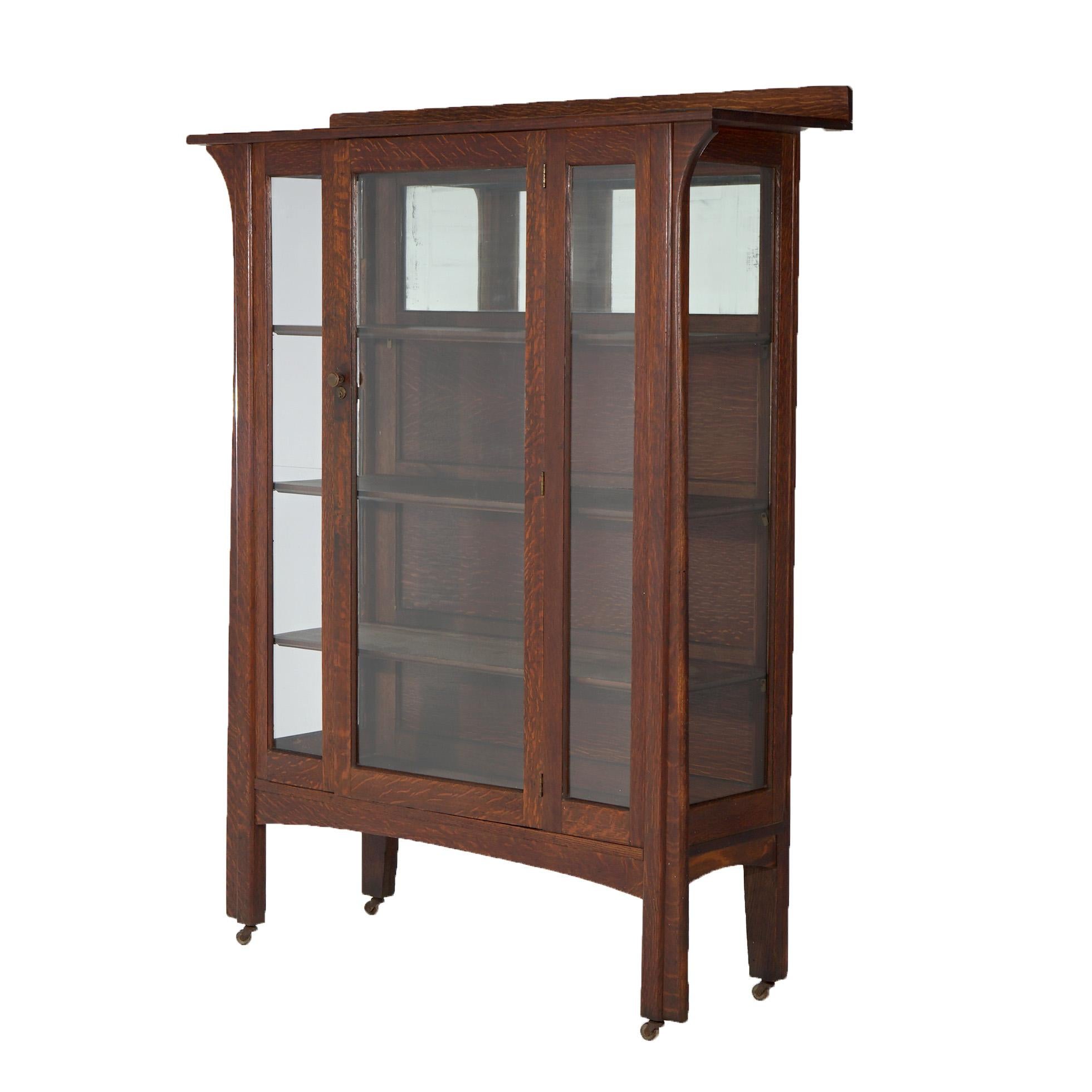 An antique Arts and Crafts Mission china cabinet in the manner of Charles Limbert offers oak construction with double glass doors opening to shelved and mirrored interior, c1910

Measures - 62