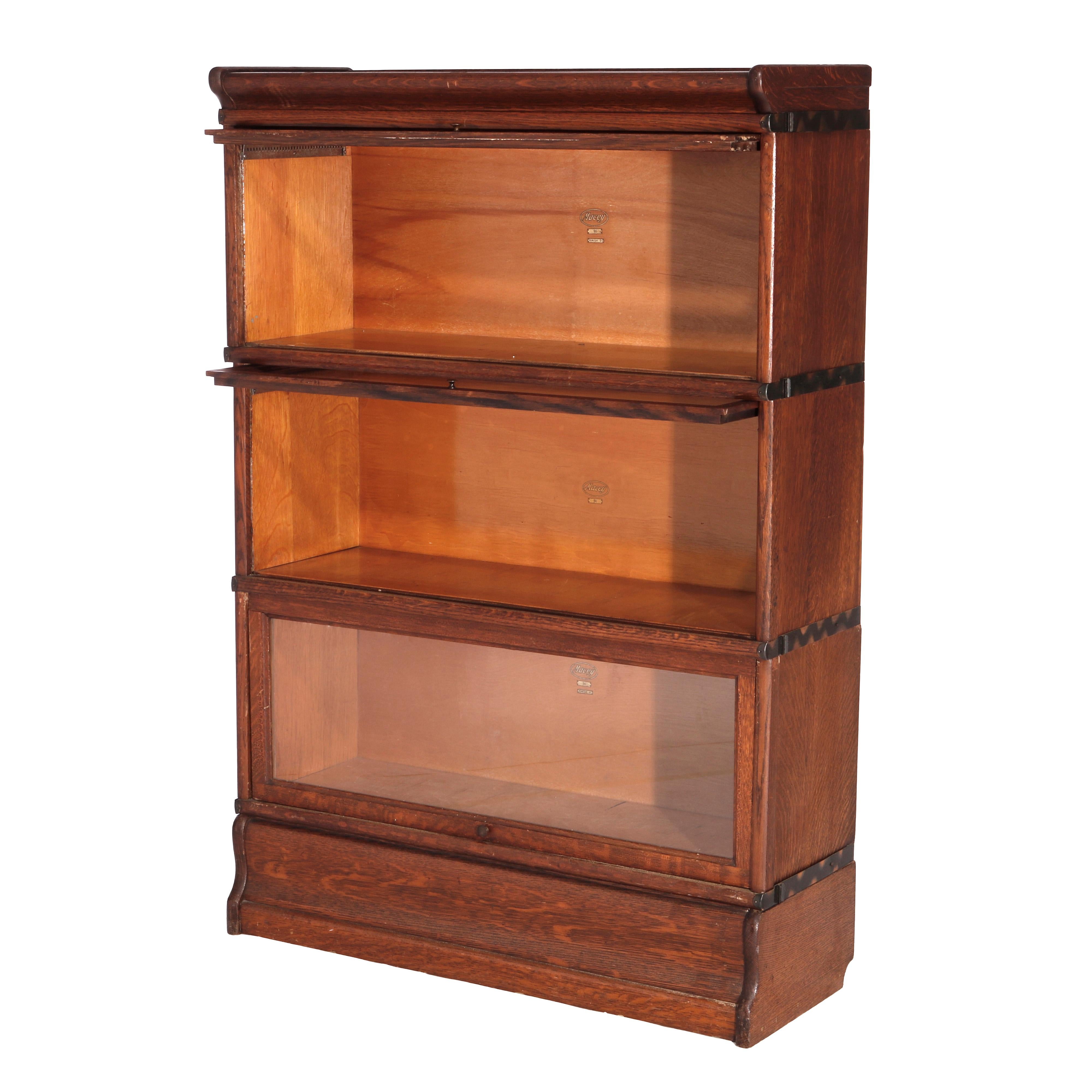 An antique Arts & Crafts Mission barrister bookcase by Macey offers oak construction with three stacks, each having pull out glass doors, raised on an ogee base, maker label as photographed, c1910

Measures - 49.5