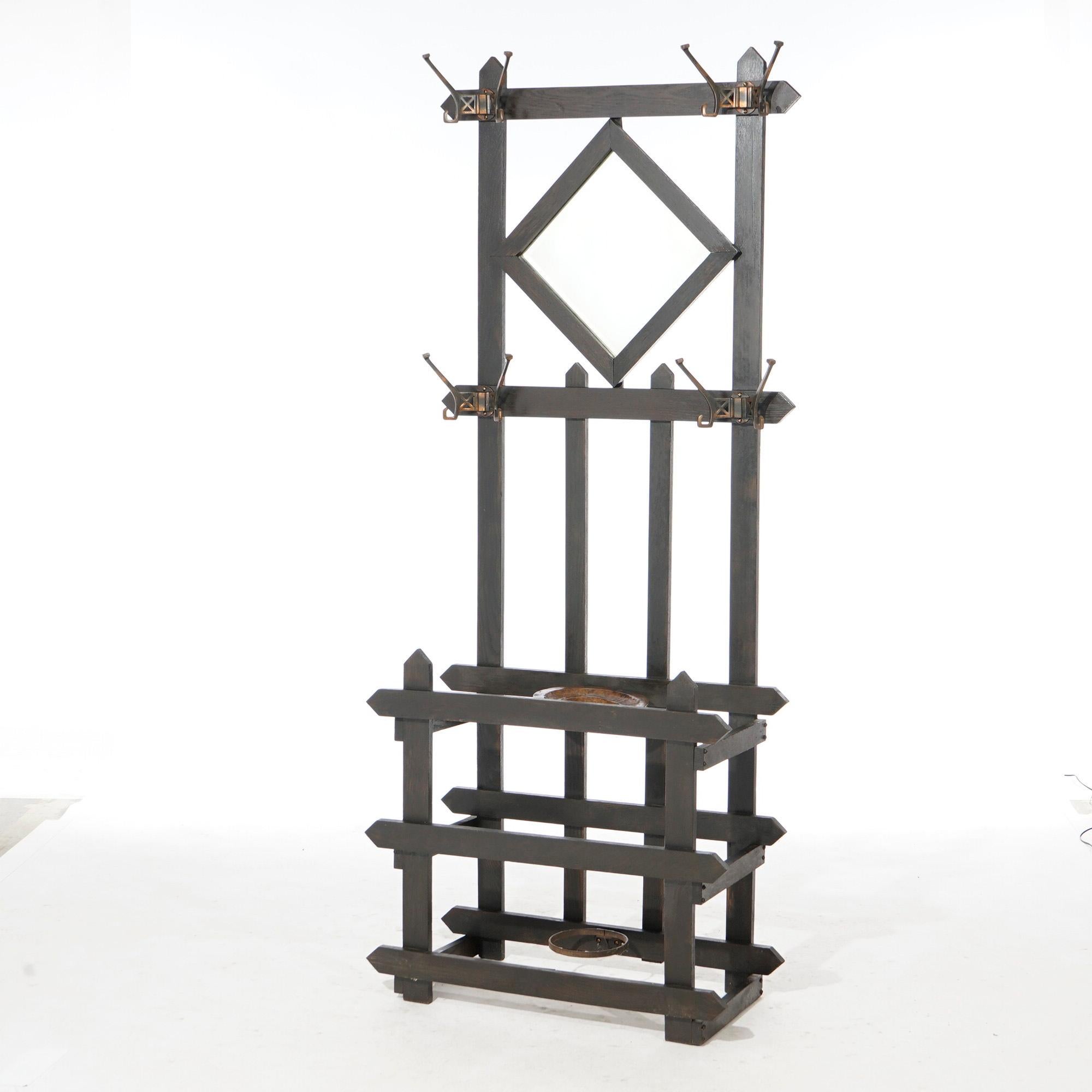 An antique Arts and Crafts Mission hall tree offers slat construction with upper mirror and flanking coat/hat hooks over umbrella stand with copper ash tray, c1910

Measures- 73.5''H x 30''W x 14