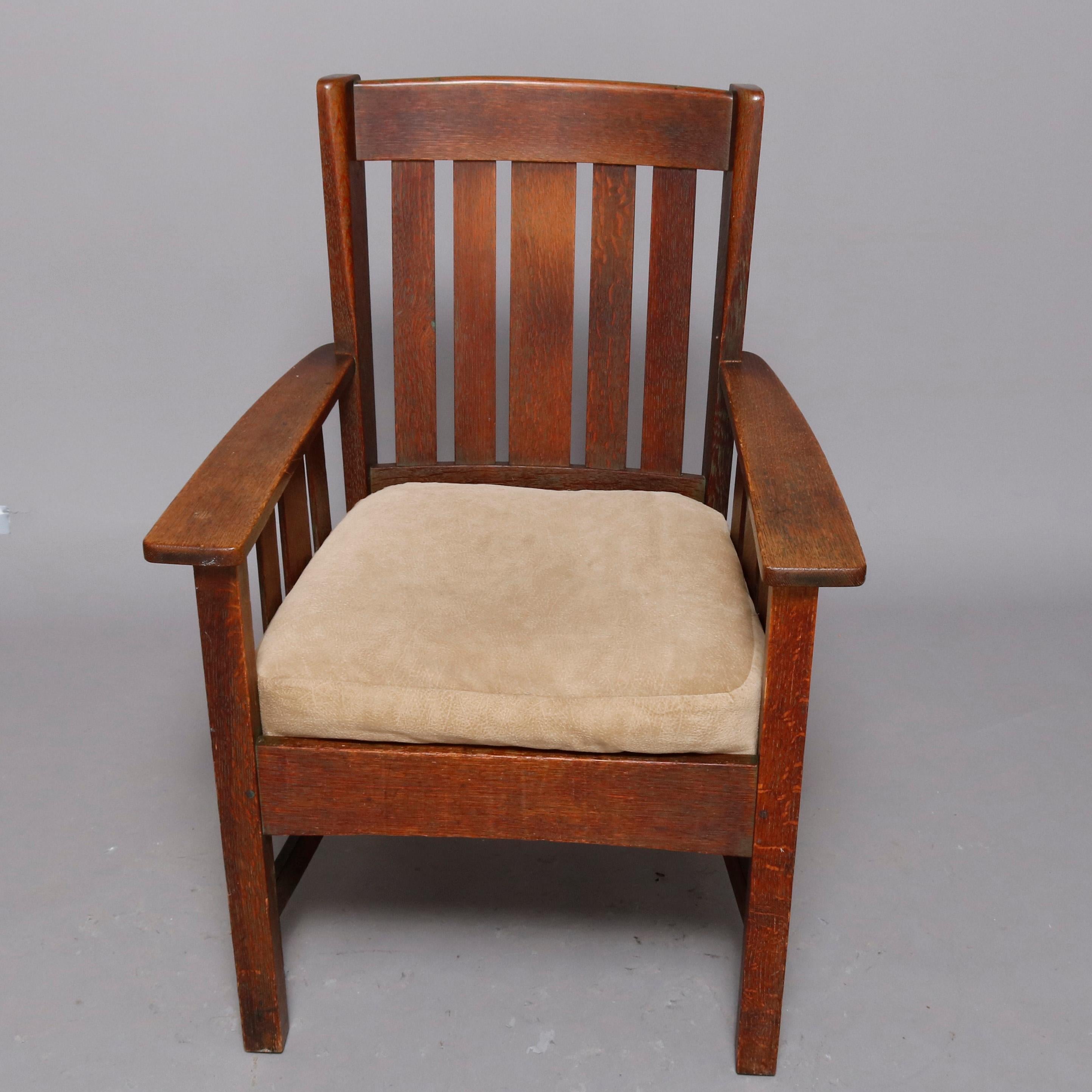 An antique Arts & Crafts Mission oak wing back chair by Stickley Brothers offers Model 405 1/2 having quarter sawn oak construction with slat backs having flanking wings and slat arms with cushion and raised on straight and square legs, model number