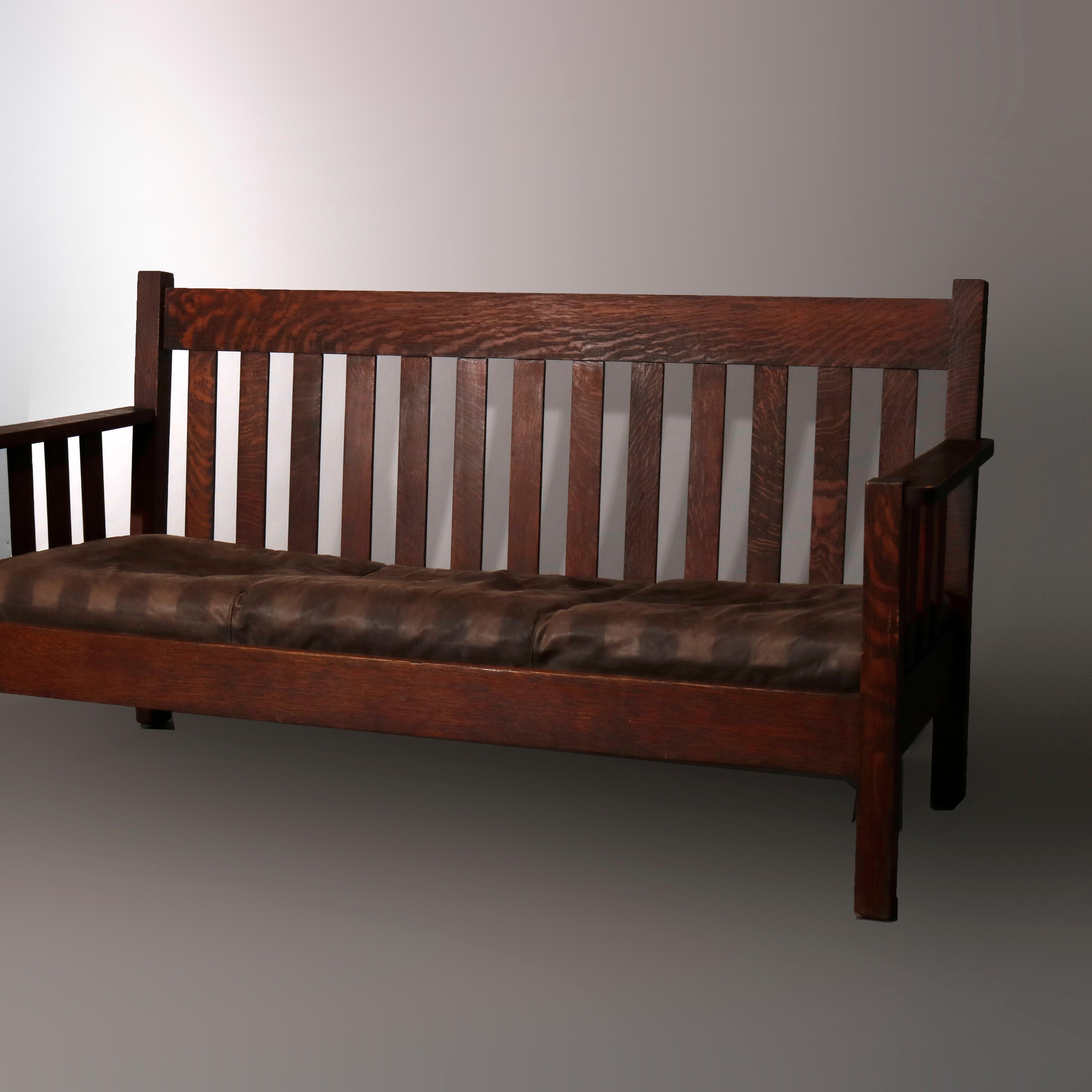 An antique Arts and Crafts Mission sofa in the manner of Stickley Brothers offers quarter sawn oak construction with slat back and sides, raised on square and straight legs, c1910

Measures - 37.5