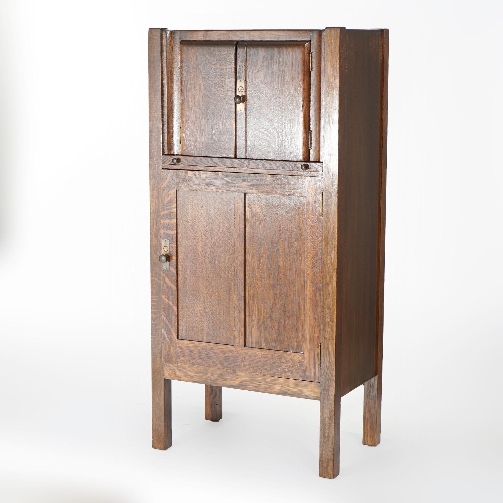 An antique Arts & Crafts mission cellarette offers quarter sawn oak construction with upper and lower double door cabinets, raised on straight and square legs, c1910.

Measures- 49.25''H x 23.25''W x 14.75''D.