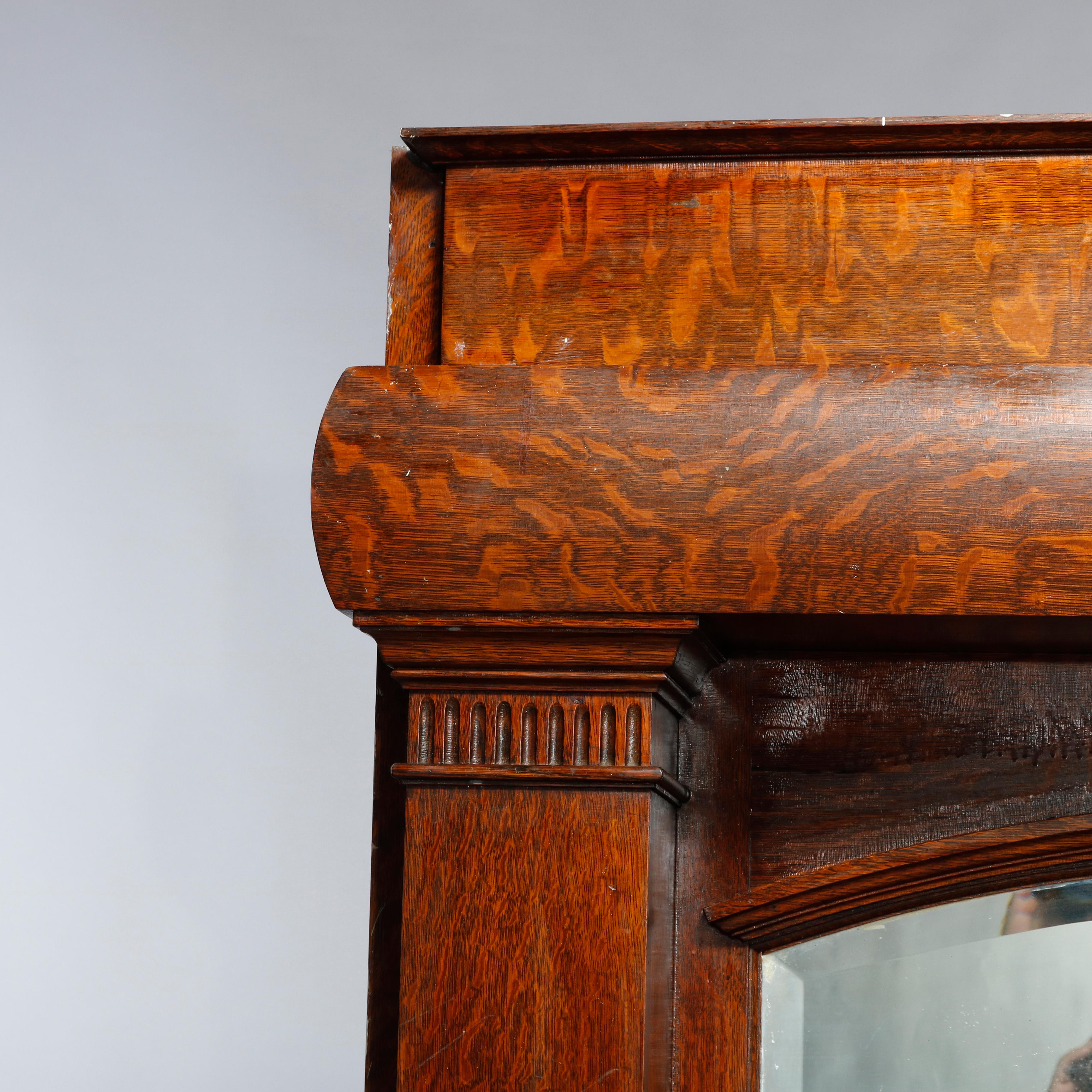 An antique Arts and Crafts Mission fireplace mantle in the manner of Stickley offers quarter sawn oak construction with upper convex shelf over arched mirror and flanking columns with carved capitals, c1910.

Measures: 88.5