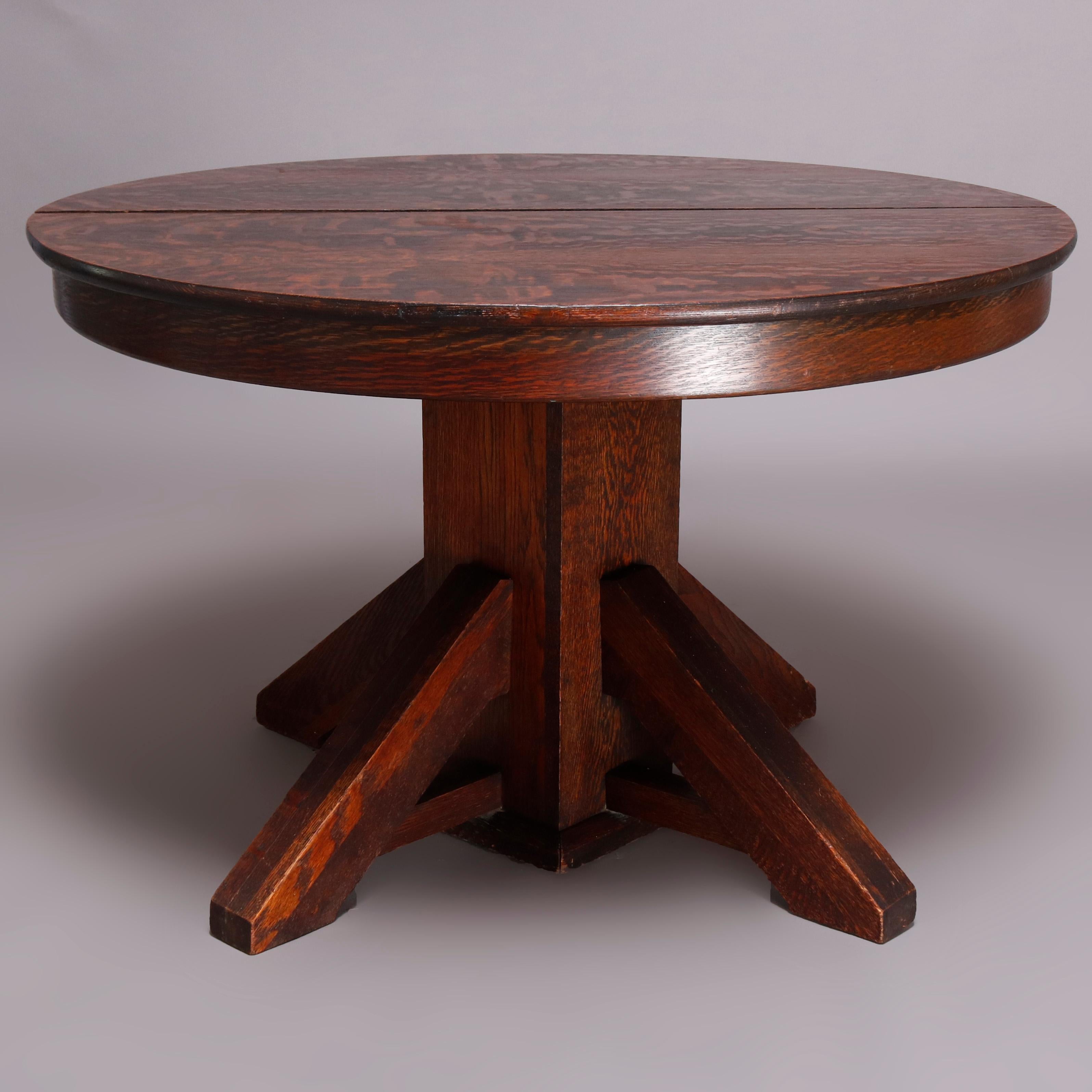 An antique Arts & Crafts mission Stickley style dining table offers quarter sawn oak construction with a round expanding top accepting three leaves and raised on a quadrapod pedestal base, circa 1910.

Measures: 27.75