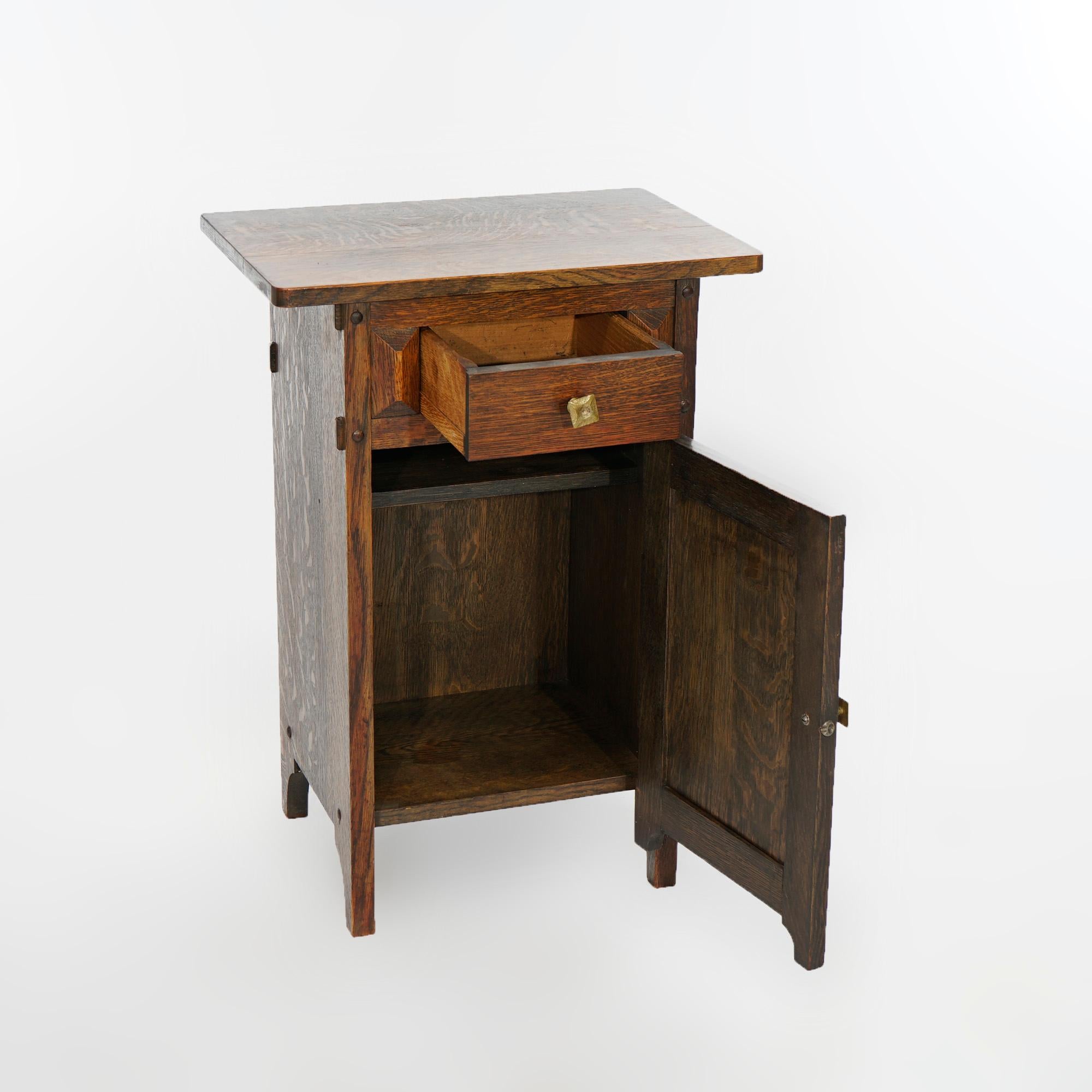 An Arts & Crafts Mission smoking stand in the manner of Stickley offers quarter sawn oak construction with single drawer over lower cabinet (both paneled), raised on bracket feet, c1910

Measures- 28''H x 20''W x 13.75''D.