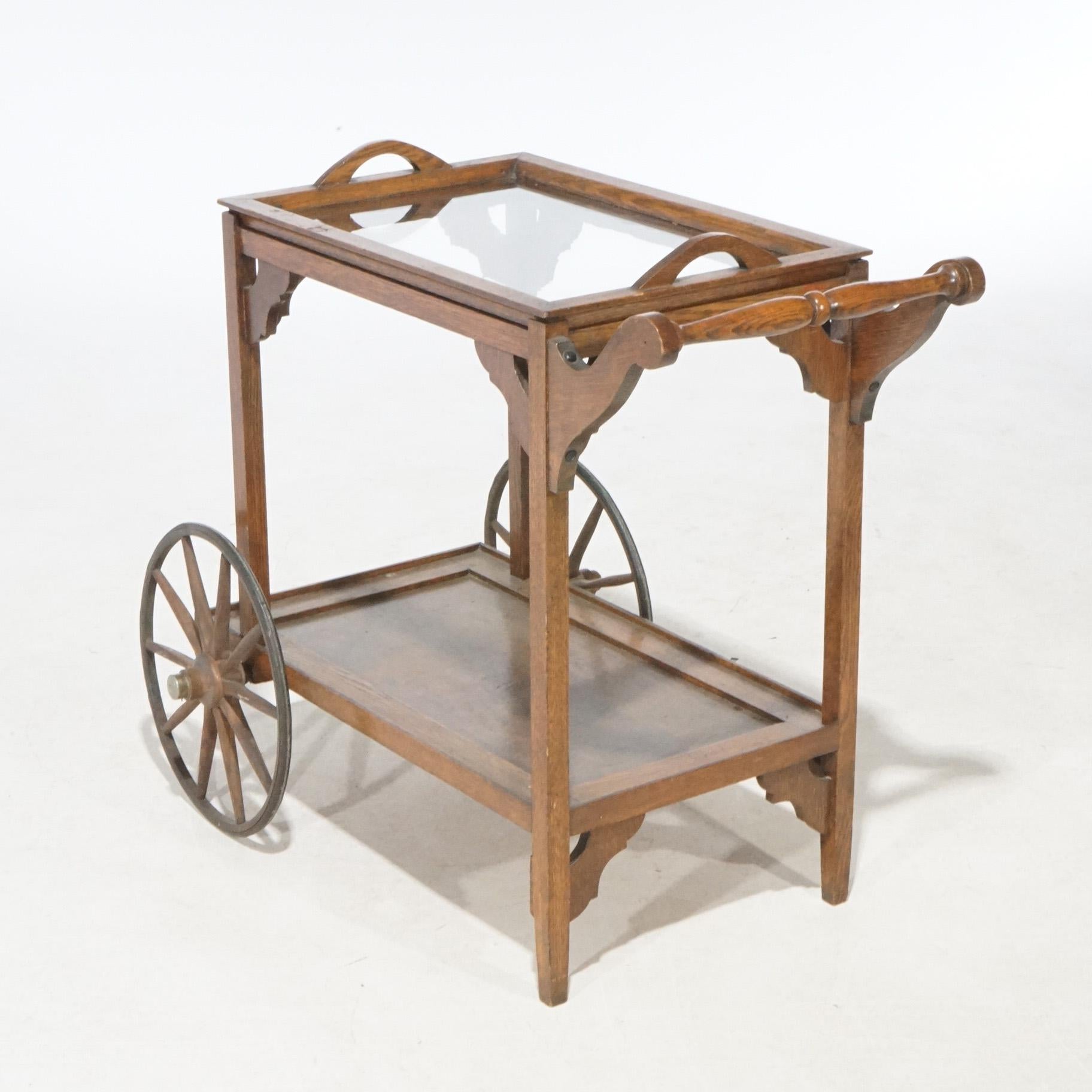 An antique Arts and Crafts tea cart offers oak construction with removeable serving tray and oversized wheels, circa 1910

Measures - 30.5