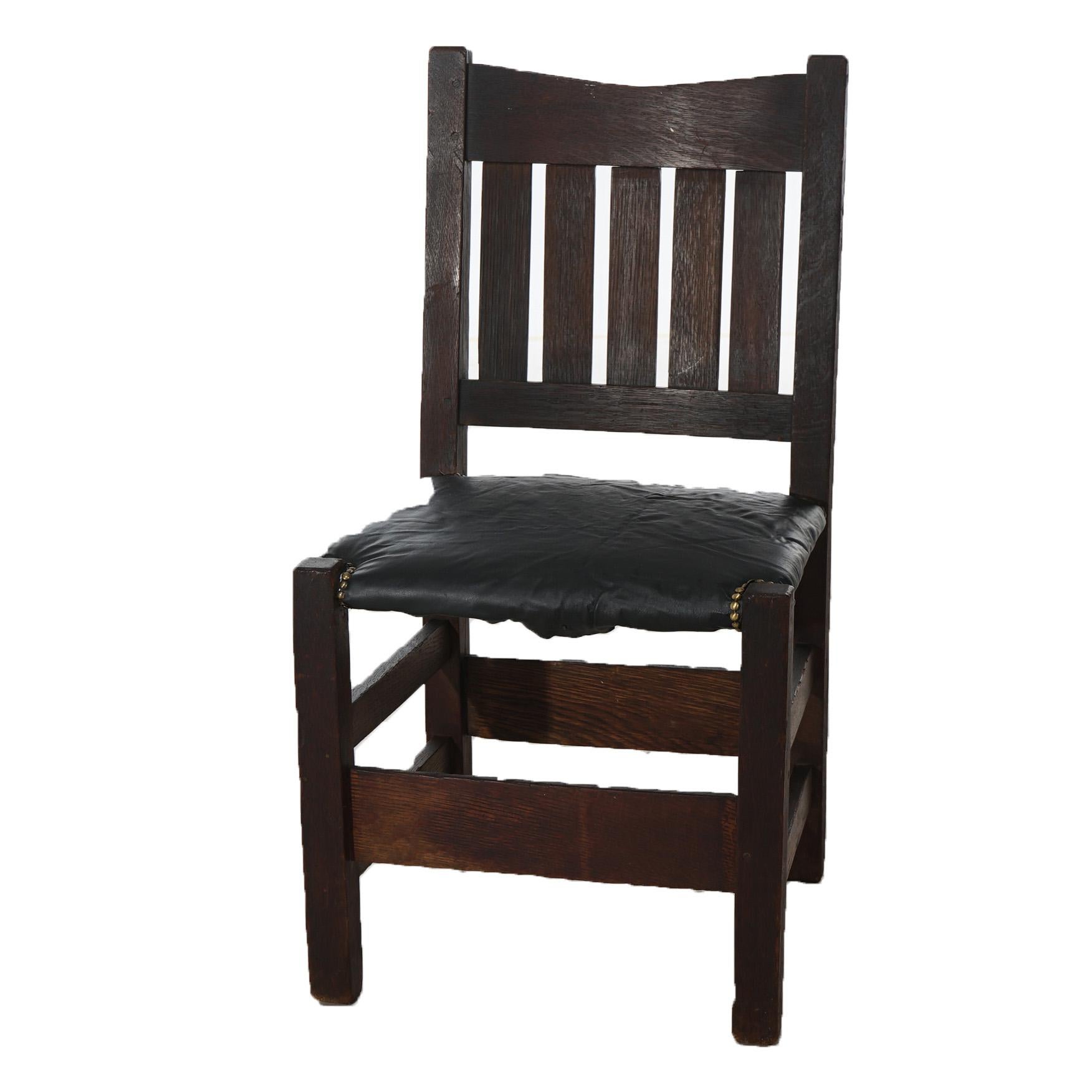 An antique Arts and Crafts v-back side chair by Gustav Stickley offers oak construction with slat back, upholstered seta and raised on square and straight legs, signed as photographed, c1905.

Measures - 35.5