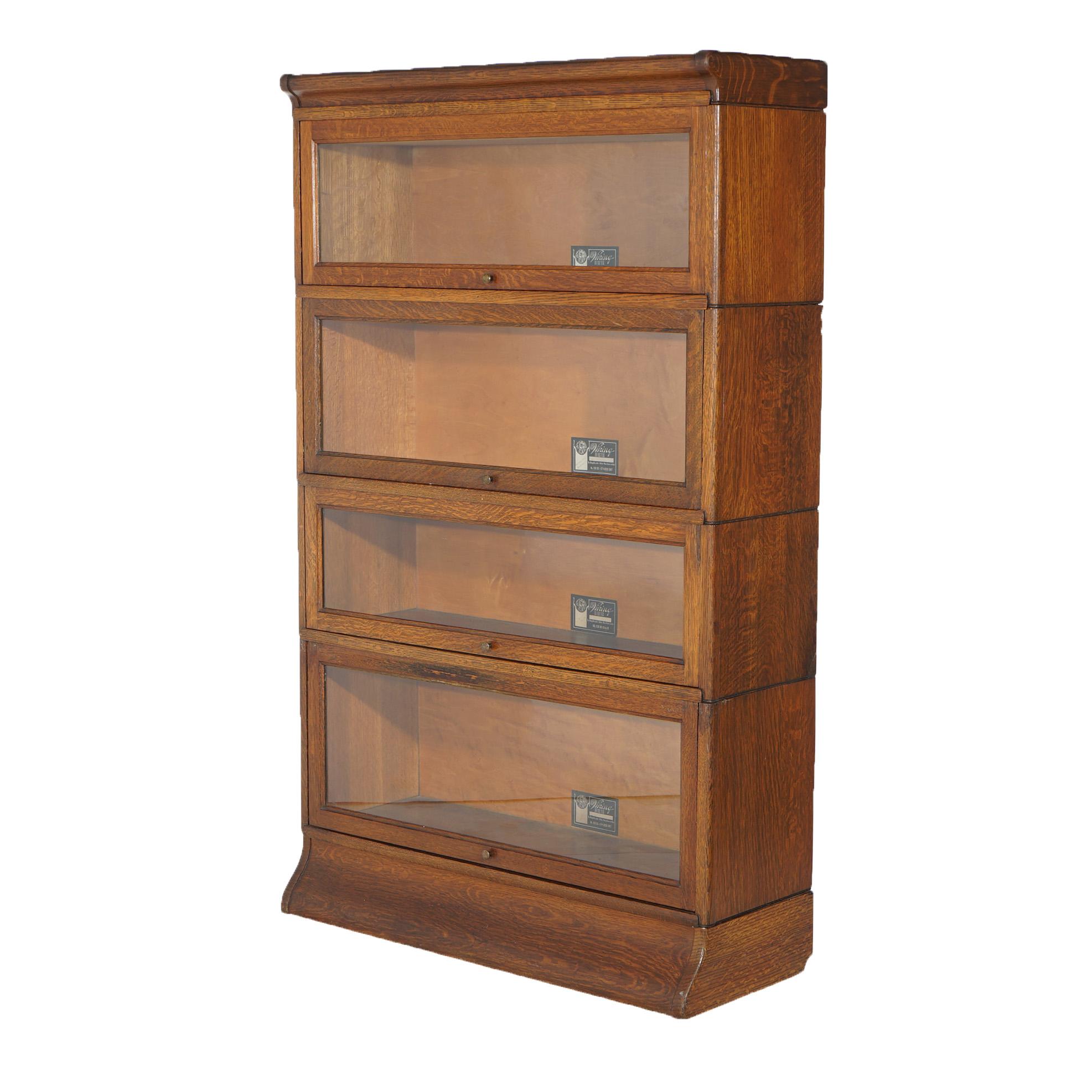 An antique Arts and Crafts Mission barrister bookcase by Viking offers oak construction with four stacks, each having pull-out glass doors, raised on ogee base, maker label as photographed, c1910

Measures - 55.5