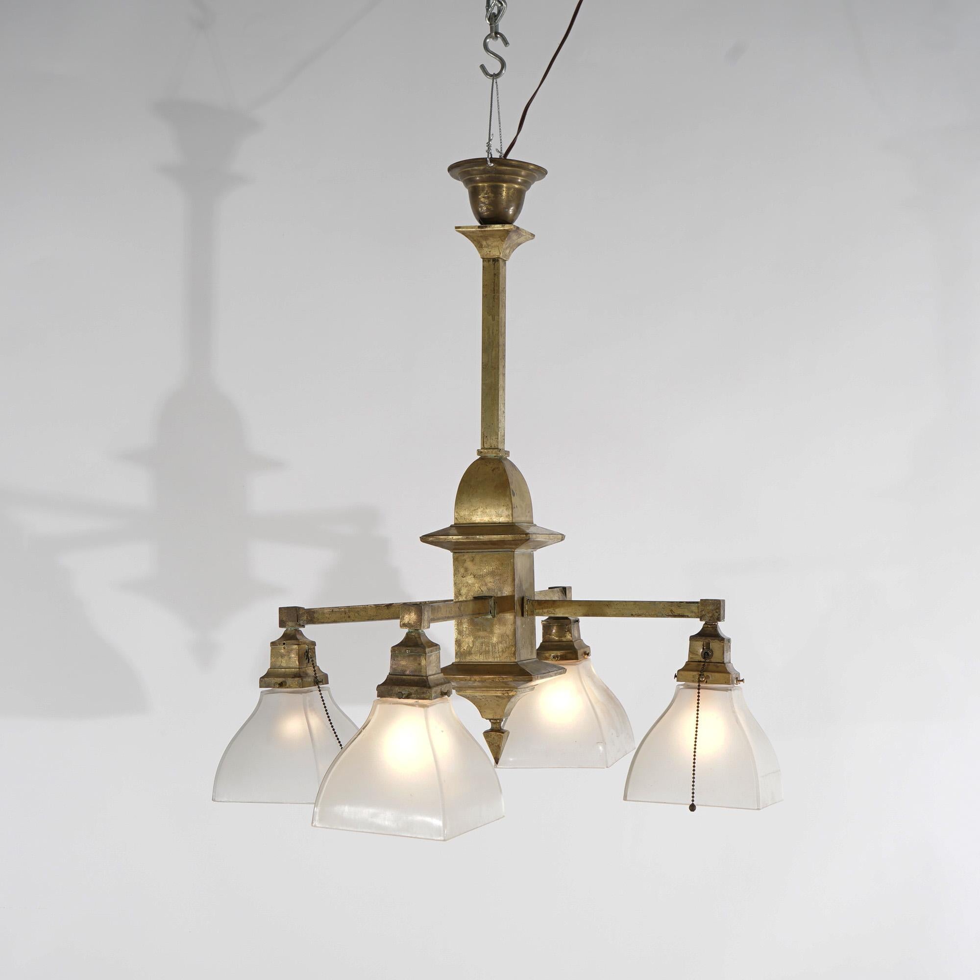 An antique Arts and Crafts Mission style chandelier offers central architectural form frame with four drop lights terminating in glass shades, c1910

Measures- 29''H x 26''W x 26''D