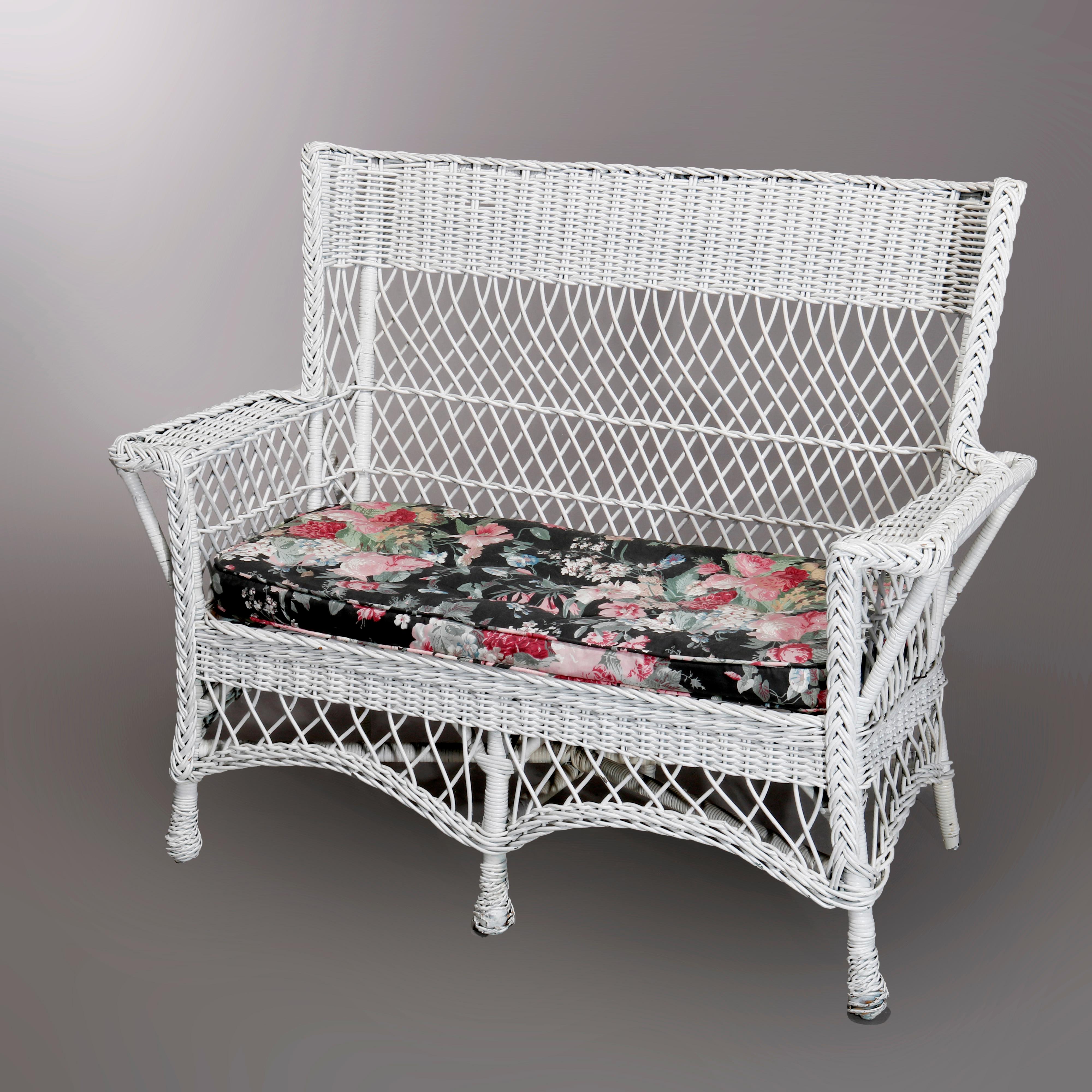 An antique Arts & Crafts Mission style settee offers wicker construction with floral cushions, c1910

Measures: 37.5