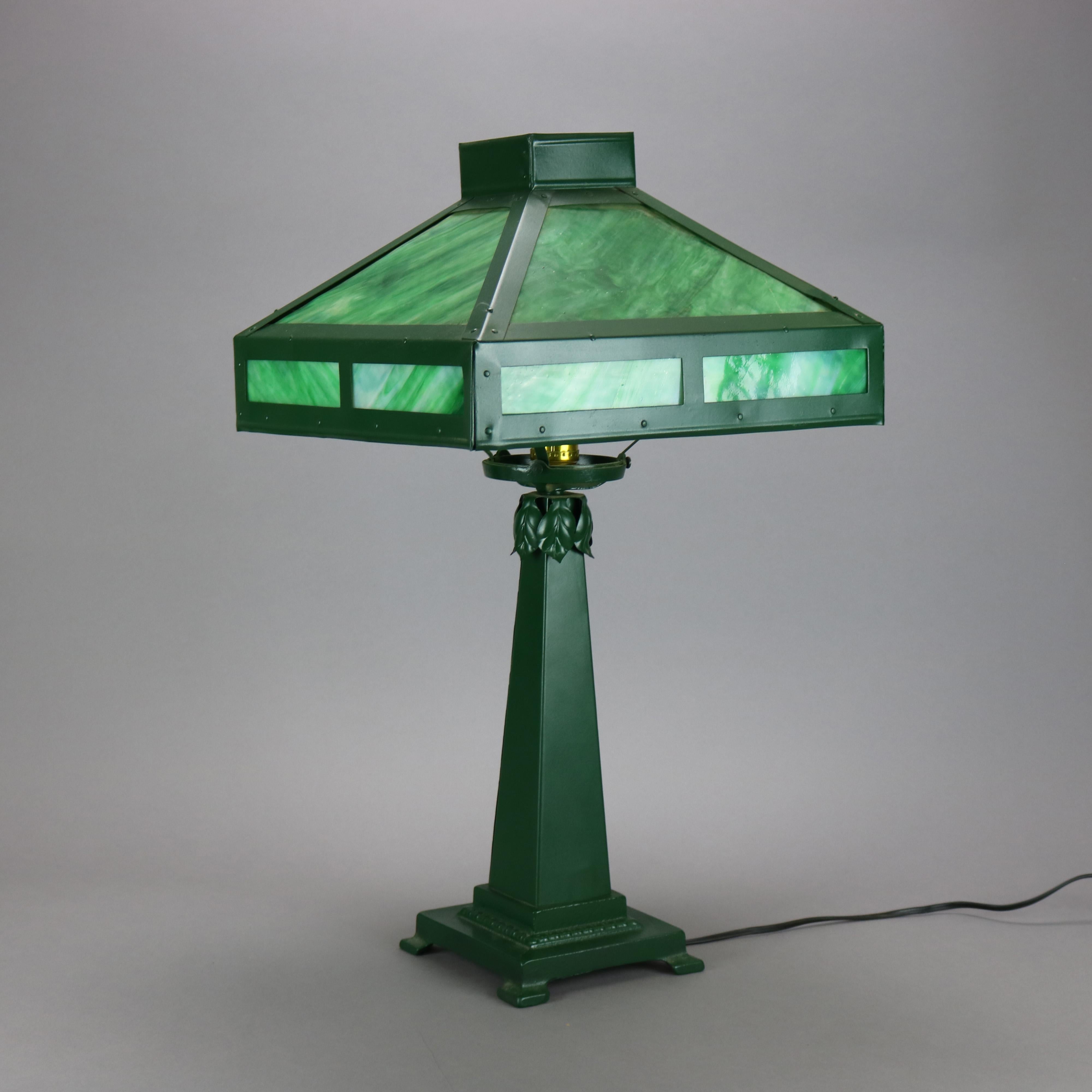 An antique Arts & Crafts Mission table lamp offers slag glass paneled shade over wrought metal single socket footed base, elements of Prairie School, c1920

Measures - 24''h x 13.5''w x 13.5''d.