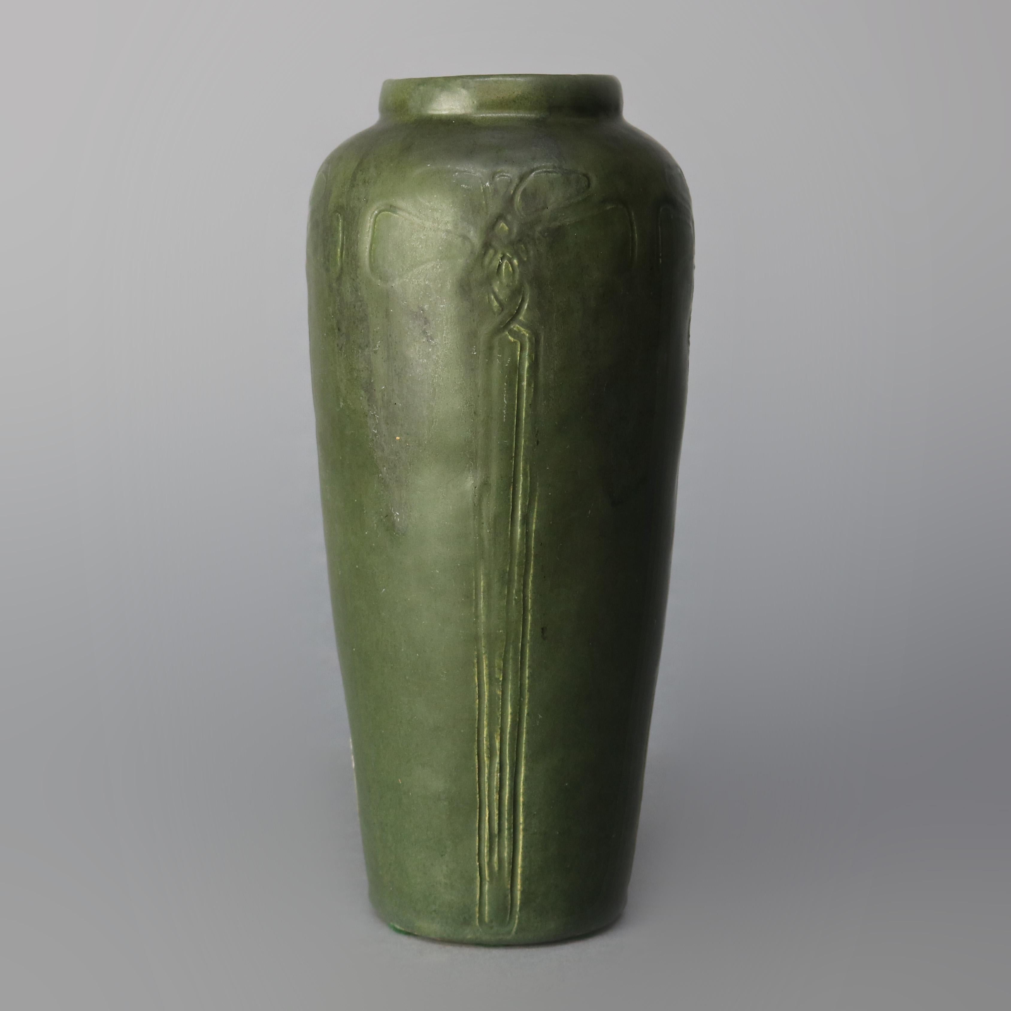 An antique Arts & Crafts art pottery vase in the manner of Grueby offers matte green glaze with repeating pattern of incised stylized flowers, artist signed CM, MC, WC, CW, EU or UE on base as photographed, elements of Marblehead and Walrath, circa