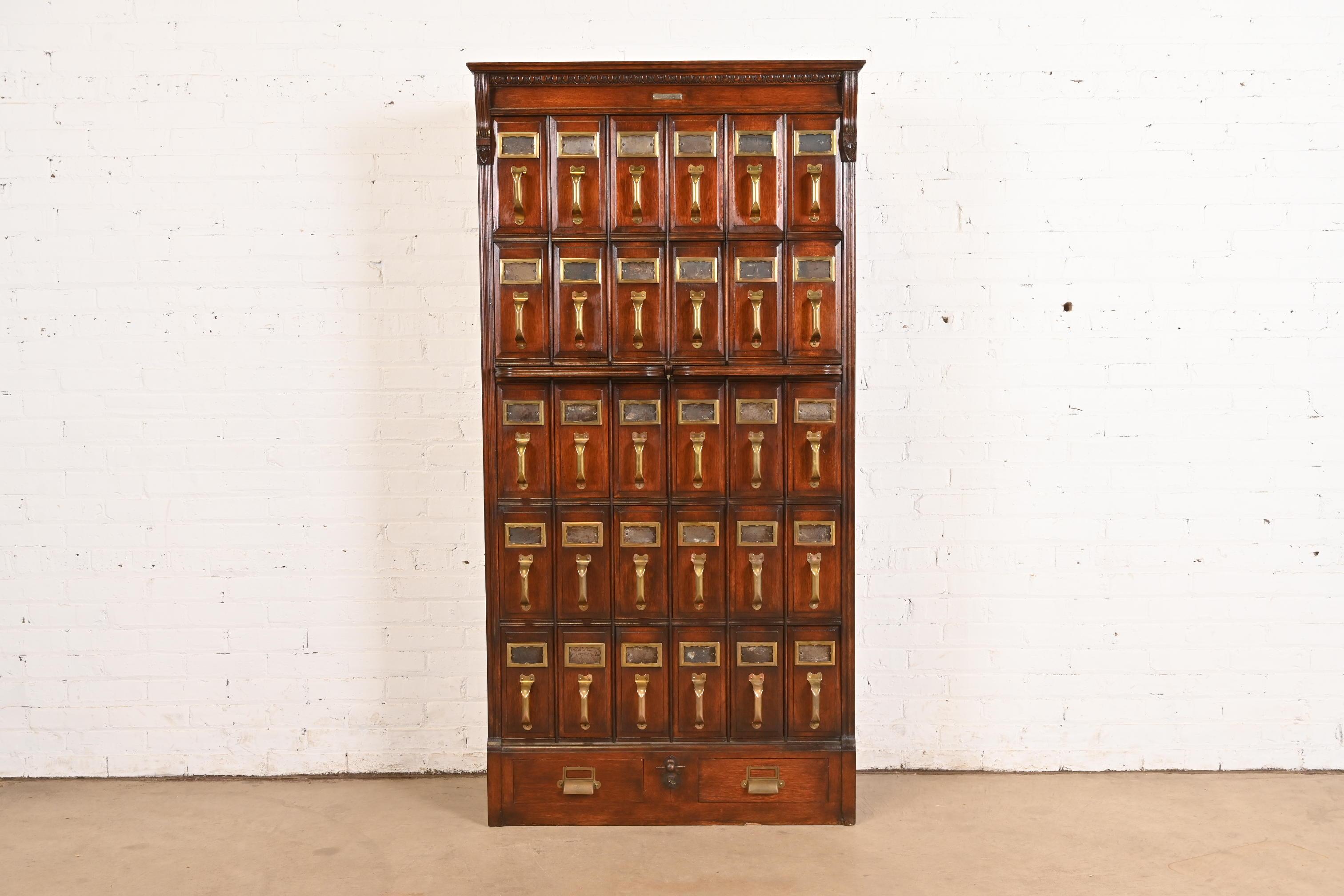 A rare and exceptional antique Arts & Crafts oak 30-drawer card catalog or file cabinet with two pull-out writing tablets

In the manner of Globe Wernicke

Produced for The Richmond & Backus Co. print shop of Detroit, MI

USA, Circa 1900

Solid oak,