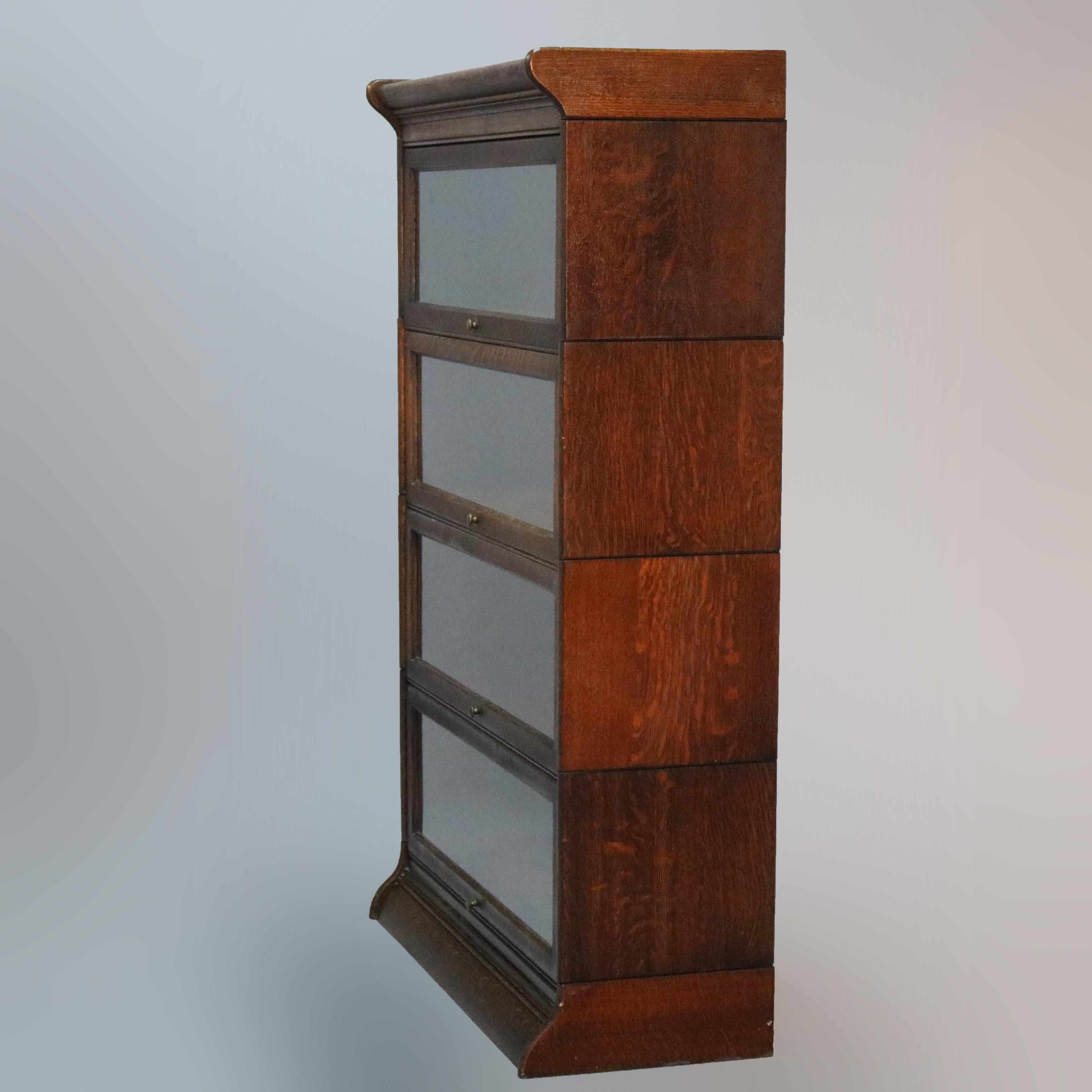 An antique Arts & Crafts Barrister bookcase by Gunn of Grand Rapids, Michigan offers quarter sawn oak construction with four stacks having pull out glass doors, seated on shaped base, original labels and maker stamp as photographed, circa
