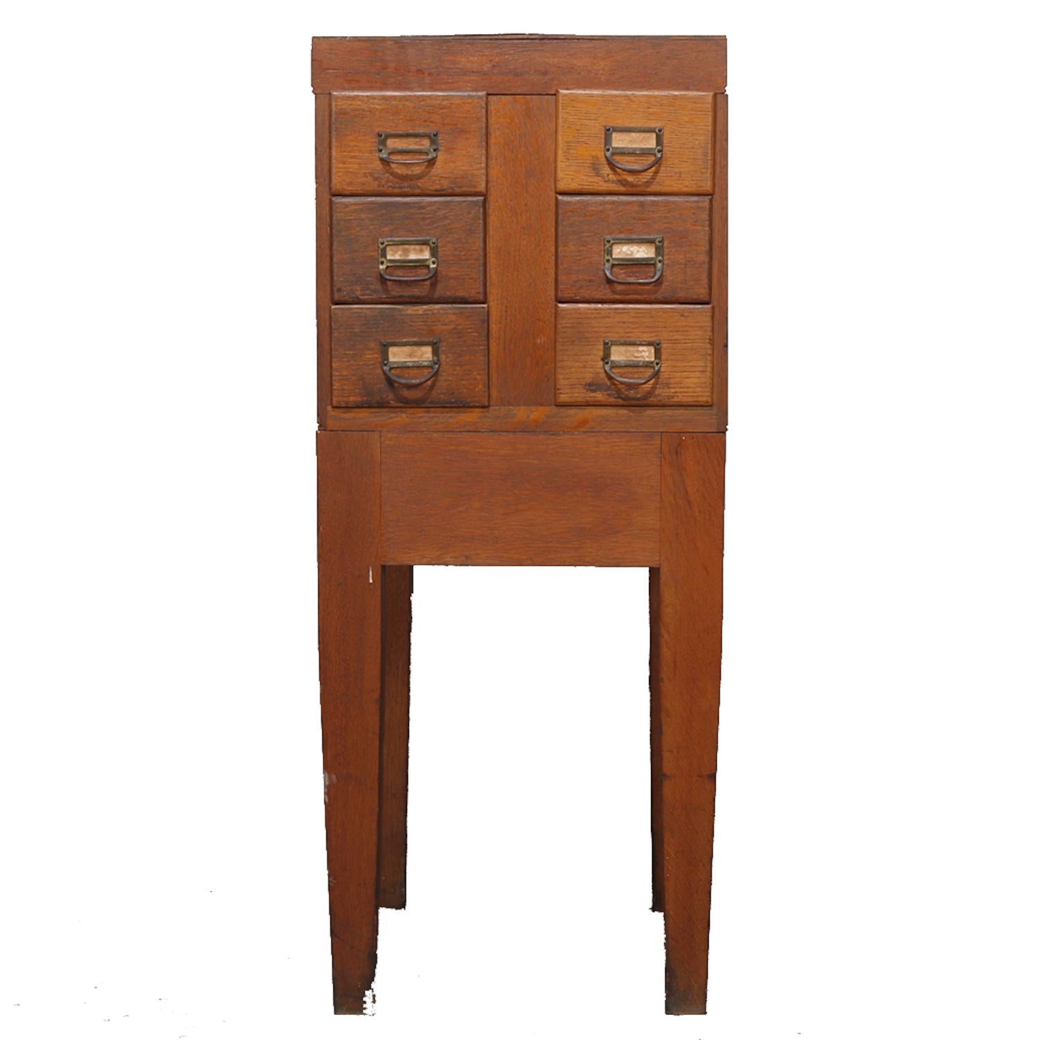 An antique Arts & Crafts filing cabinet offers quarter sawn oak construction with upper card catalog case having six drawers and seated on base with square and straight legs, circa 1910.

Measures: 39.5
