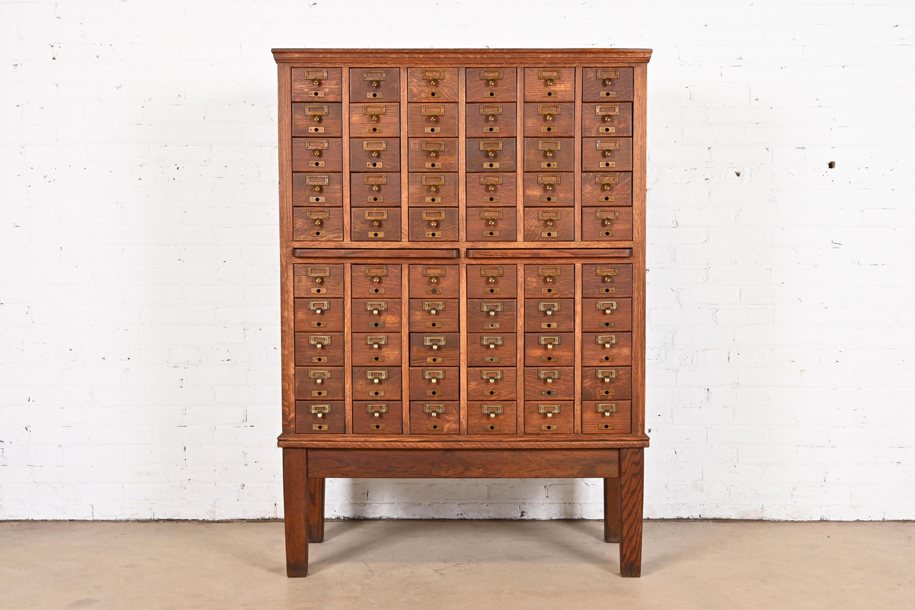 A rare and exceptional antique Arts & Crafts oak 60-drawer card catalog or file cabinet with two pull-out writing tablets

USA, Circa 1900

Solid quarter sawn oak, with brass hardware, and inset leather top writing tablets.

Measures: 42.5