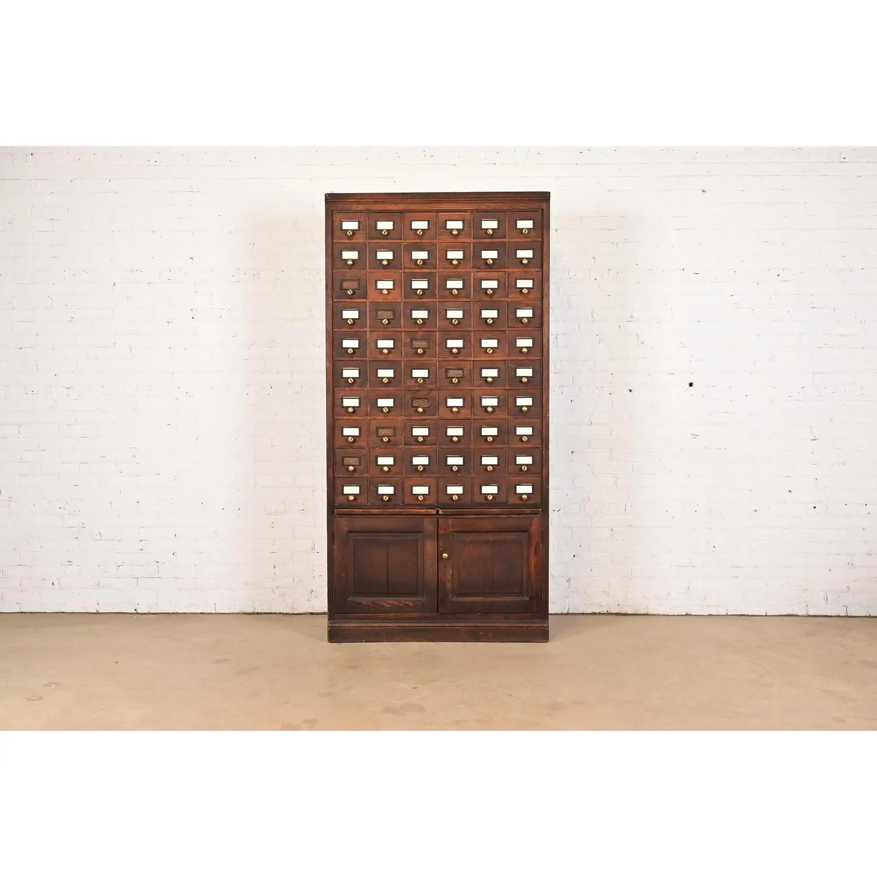 A rare and exceptional antique Arts & Crafts oak 60-drawer card catalog or file cabinet with two pull-out writing tablets

In the manner of Globe Wernicke

USA, Circa 1900

Solid oak, with original brass hardware.

Measures: 42