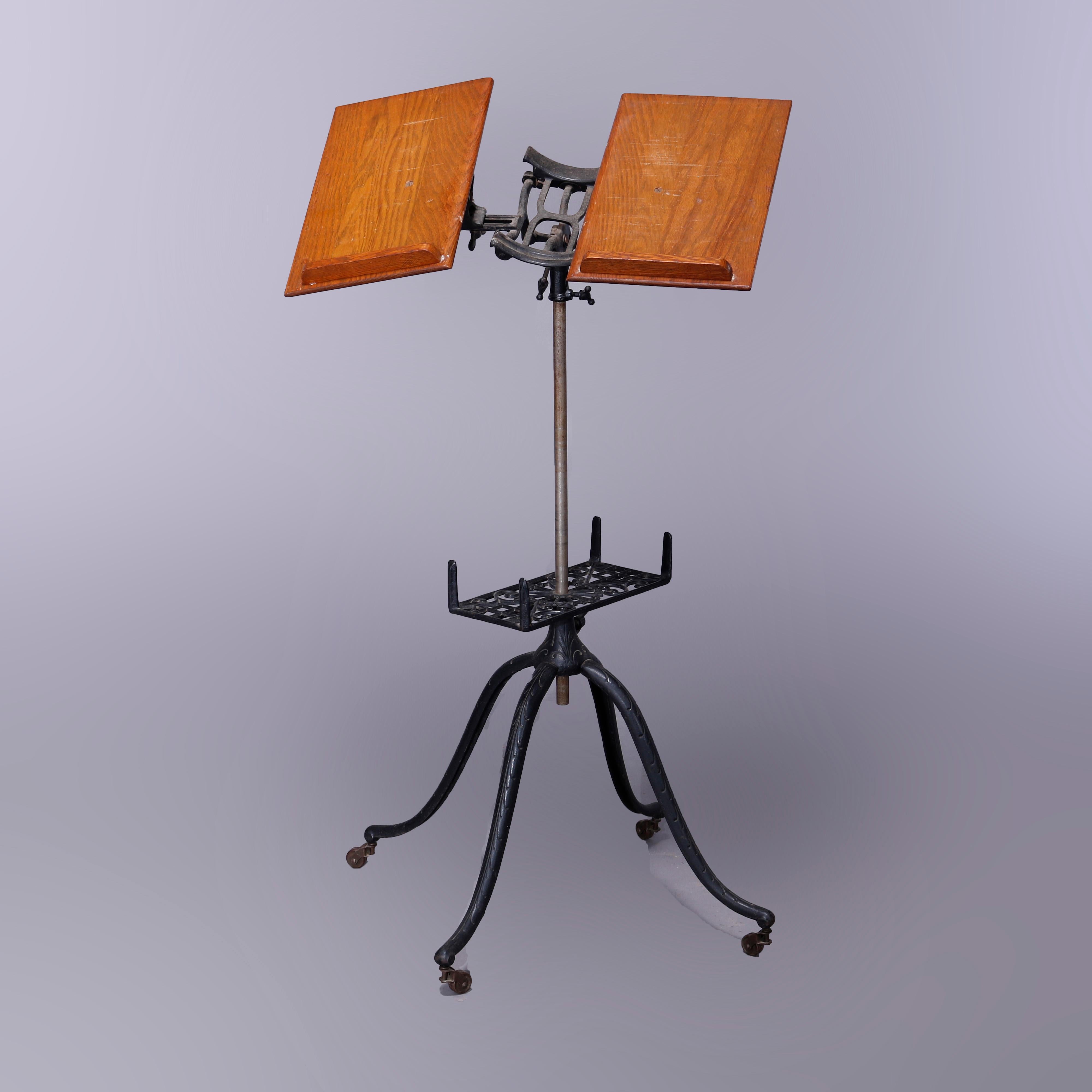 An antique Arts & Crafts library or parlor dictionary book stand offers cast iron quadripod base with cabriole legs and pierced cast foliate lower shelf surmounted by adjustable display, seated on casters, circa 1920.

Measures - 47''H x 23.25''W x