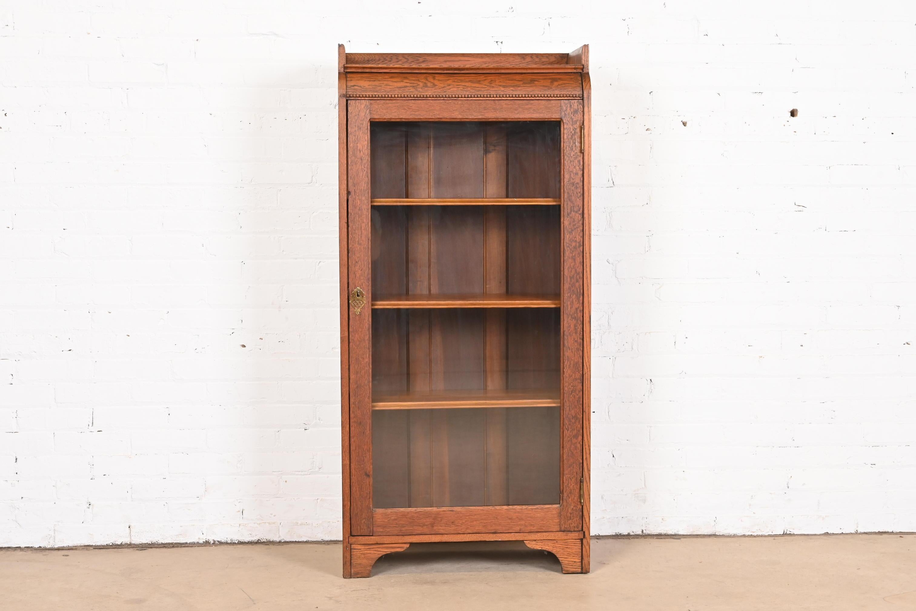 A gorgeous antique Mission or Arts & Crafts bookcase cabinet

In the manner of Stickley Brothers

USA, Circa 1900

Solid oak, with glass front door and original brass hardware. Cabinet locks, and key is included.

Measures: 25.5