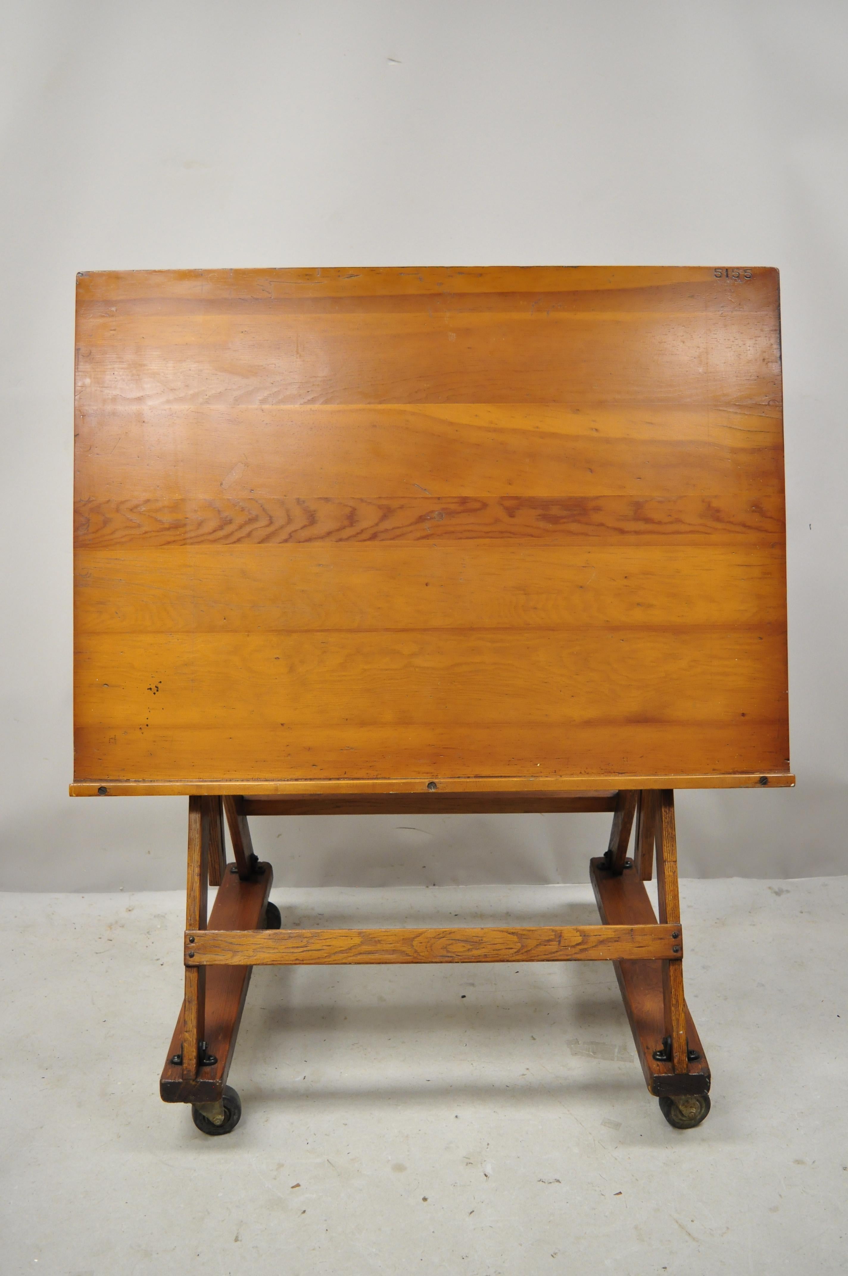 Antique Arts & Crafts oak cherry pine wood artist drafting table on wheels. Item features smooth rolling wheels, adjustable height and tilting top, solid wood construction, beautiful wood grain, very nice antique item, circa early to mid-1900s.