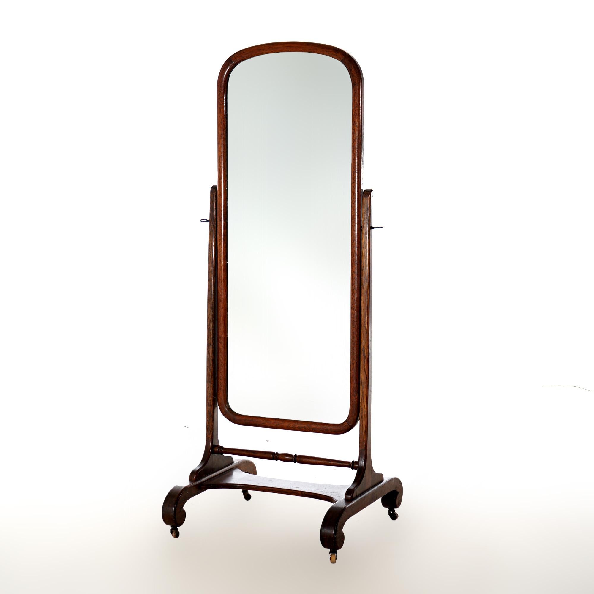 An antique Arts and Crafts cheval dressing mirror offers oak frame with full length mirror on base having turned stretcher and raised on scroll form legs, c1910

Measures - 68