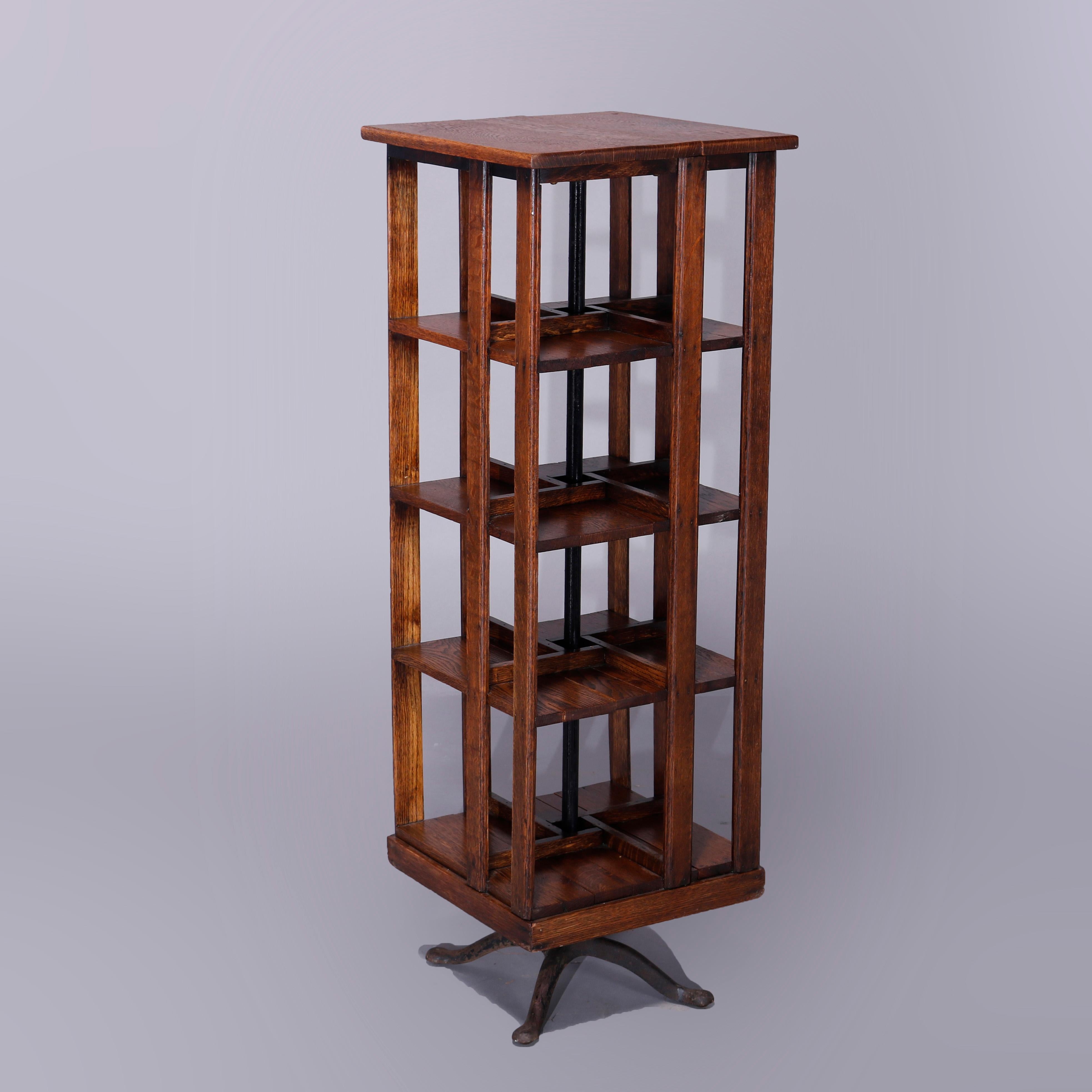 An antique Arts & Crafts revolving bookcase in the manner of Danner offers oak construction with slat sides, four shelves and raised on cast iron base, c1910

Measures - 45''H x 15.5''W x 15.5''D.