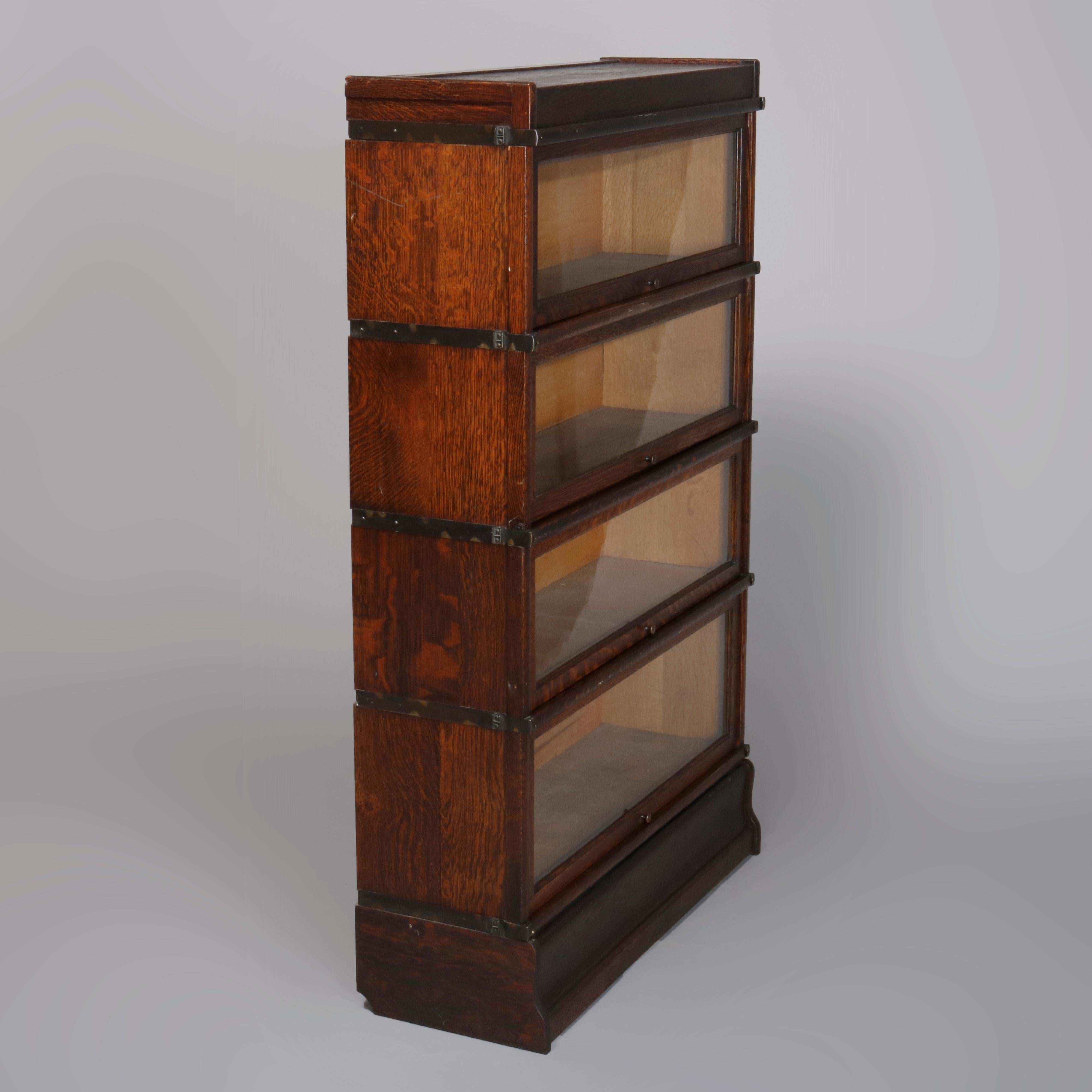 An antique Arts & Crafts mission oak Barrister bookcase by Globe Wernicke offers quarter sawn oak construction with four stacks, each having pull-out glass doors and original maker labels, circa 1920.

Measures: 54.25