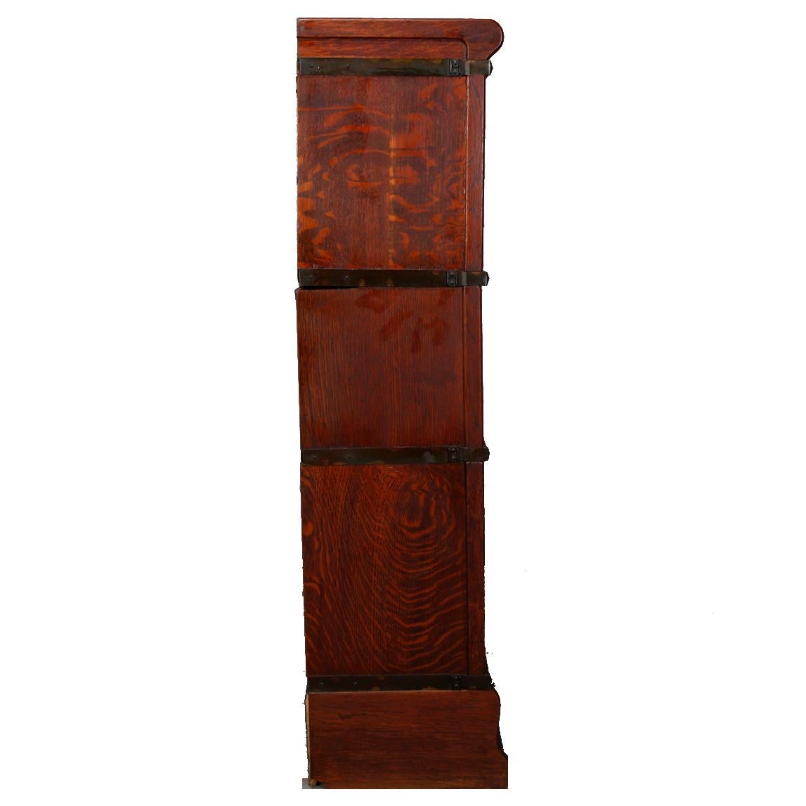 An antique Arts & Crafts barrister bookcase by Globe Wernicke offers quarter sawn oak construction with three stacks having pull out glass doors over lower ogee form drawer, original maker label as photographed, circa 1910

Measures: 47.25