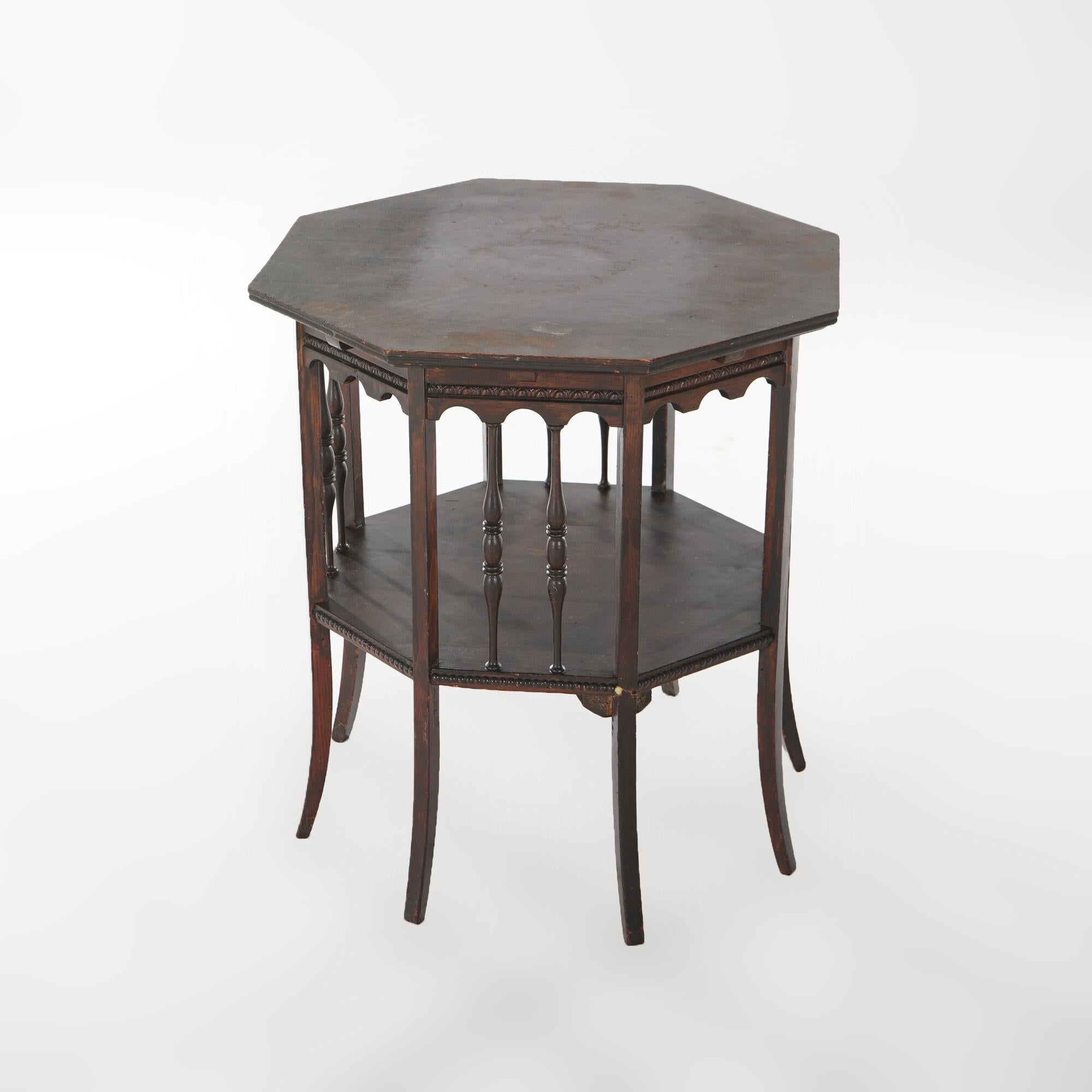 An antique Arts and Crafts side table offers oak construction with octagonal top over lower shelf with spindle supports and raised on square splayed legs, c1910

Measures - 24.25