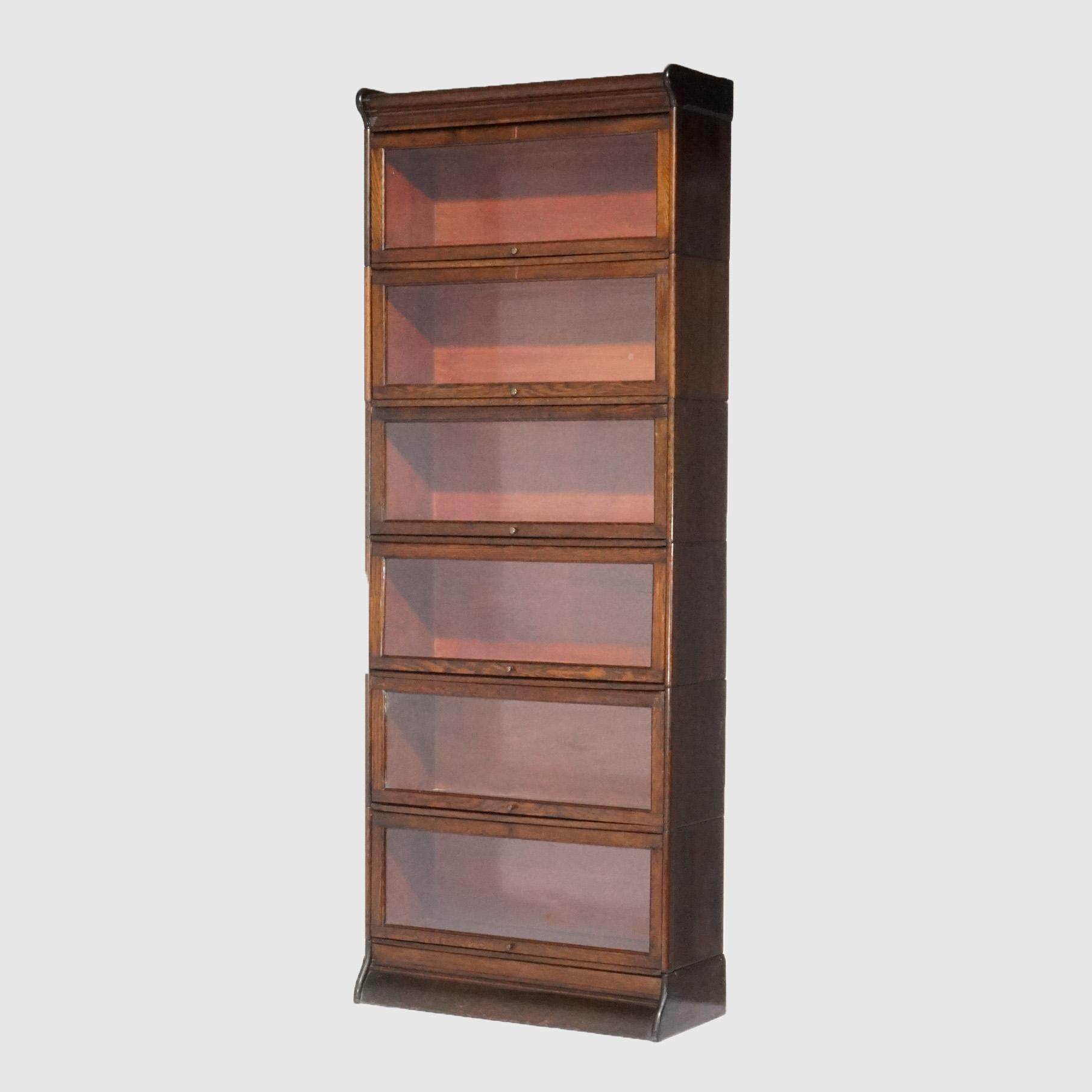 An antique Arts and Crafts barrister bookcase offers oak construction with six stacks, each having pull-out glass doors; raised on ogee base, c1910

Measures: 63''H x 34.5''W x 11.75''D; interior shelf height: 10'' 

Catalogue Note: Ask about
