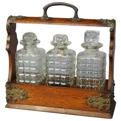 Antique Arts & Crafts Tantalus Set en chêne avec trois carafes:: circa 1900